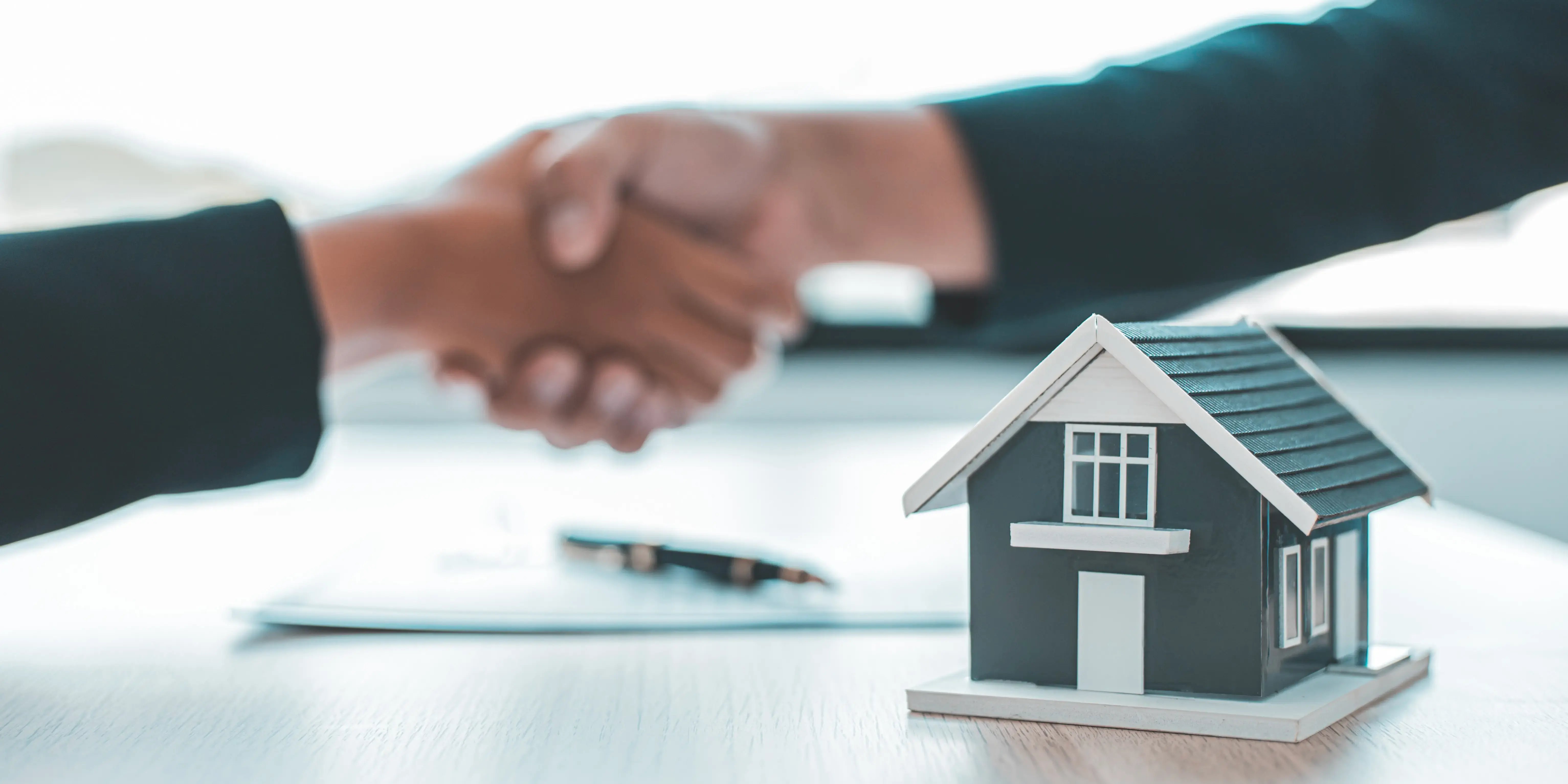 Agentes inmobiliarios y cliente se dan la mano para felicitar luego de solicitar el programa borrón y cuenta nueva Infonavit