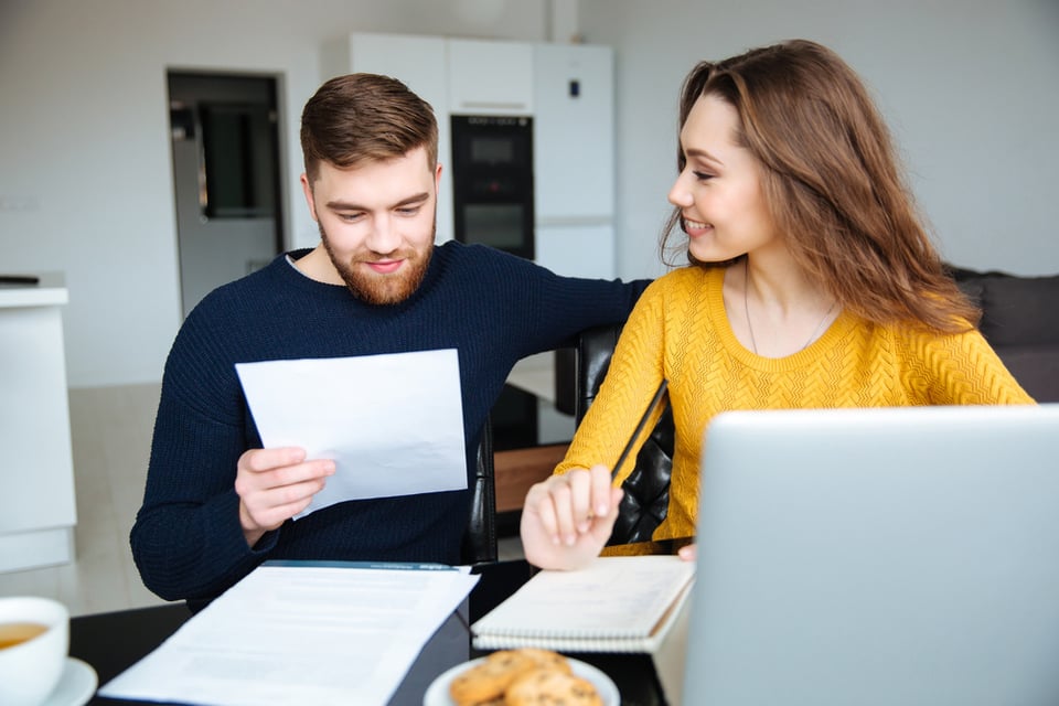 Pareja calculando sus finanzas en casa analizando deudas planeación financiera