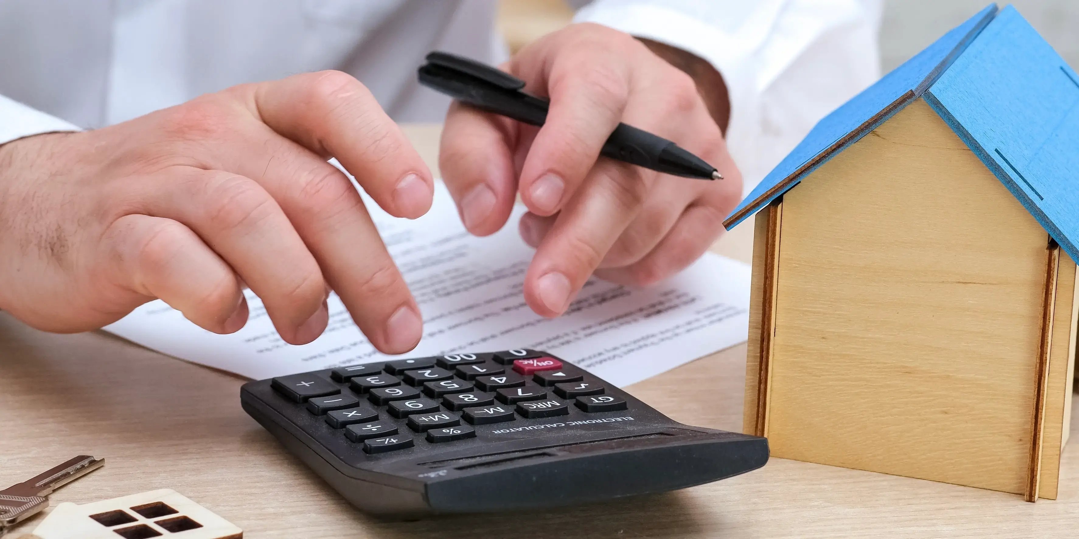 Hombre calculando el pago de la hipoteca, comparando si es con Infonavit o crédito hipotecario