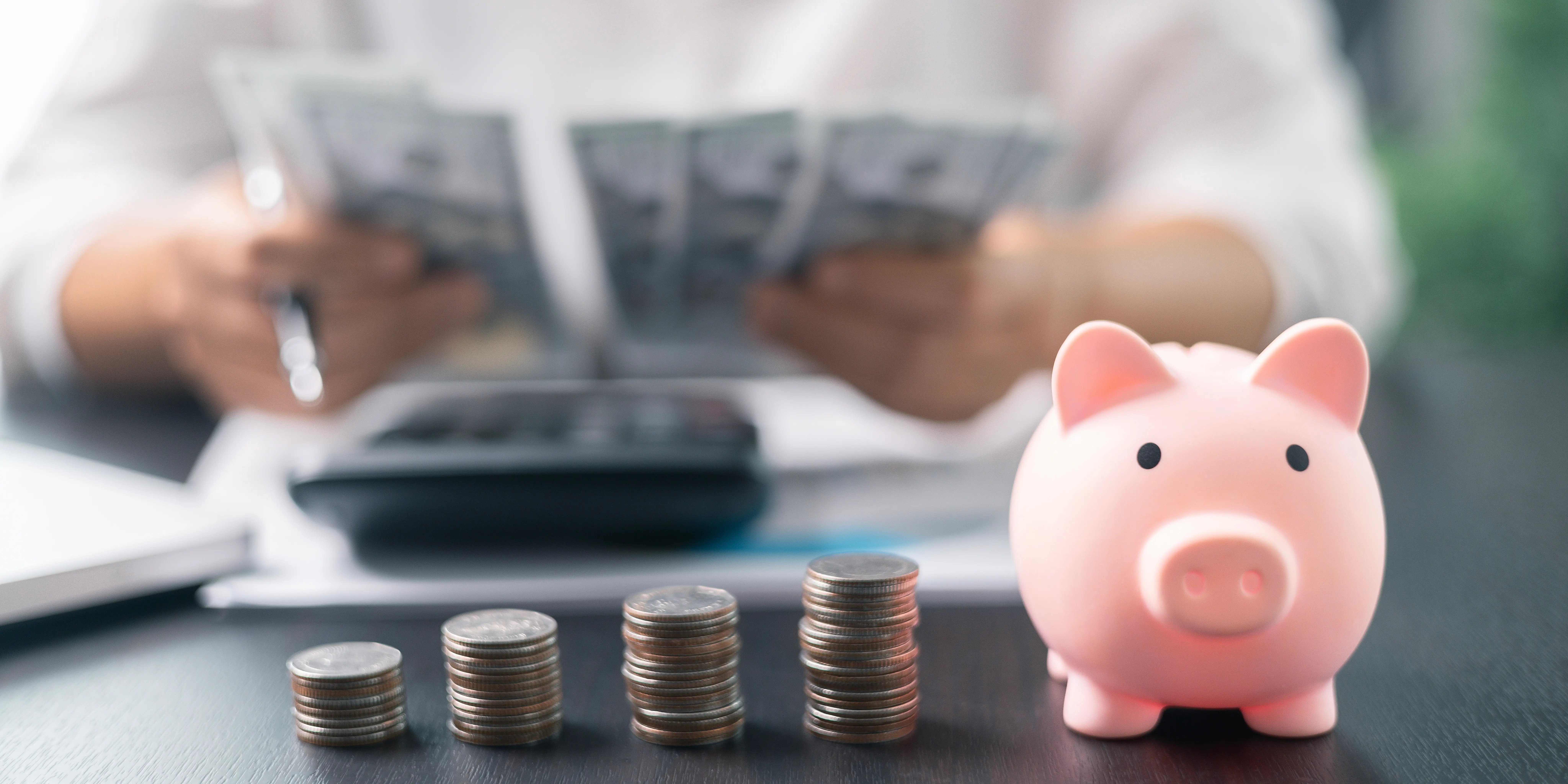 Hombre con una calculadora y sosteniendo unos billetes recalculando el saldo a pagar que tiene con borrón y cuenta nueva Infonavit