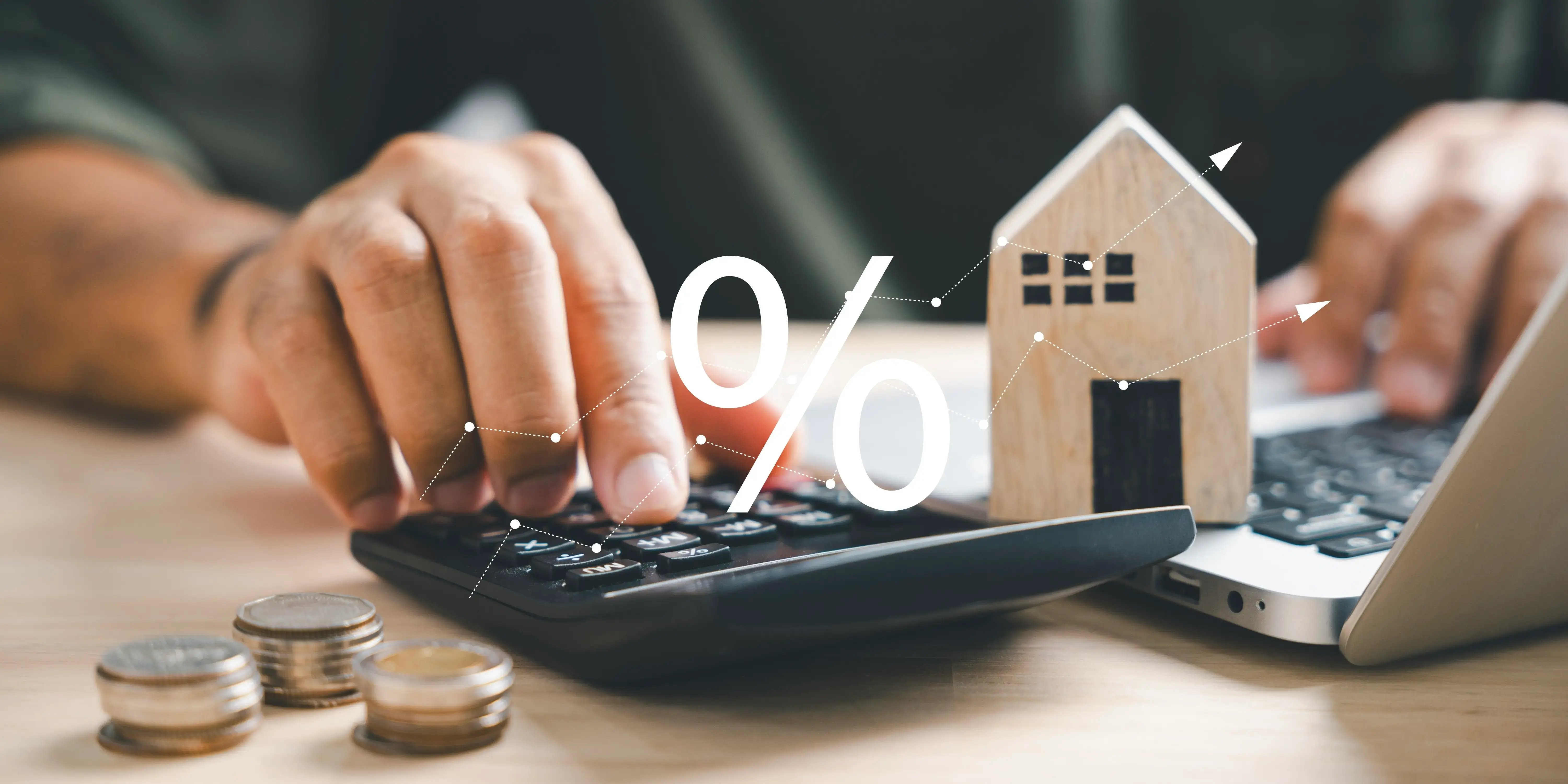 Hombre con una calculadora y unas monedas a los lados, calculando el incremento de los pagos mensuales para liquidar la hipoteca