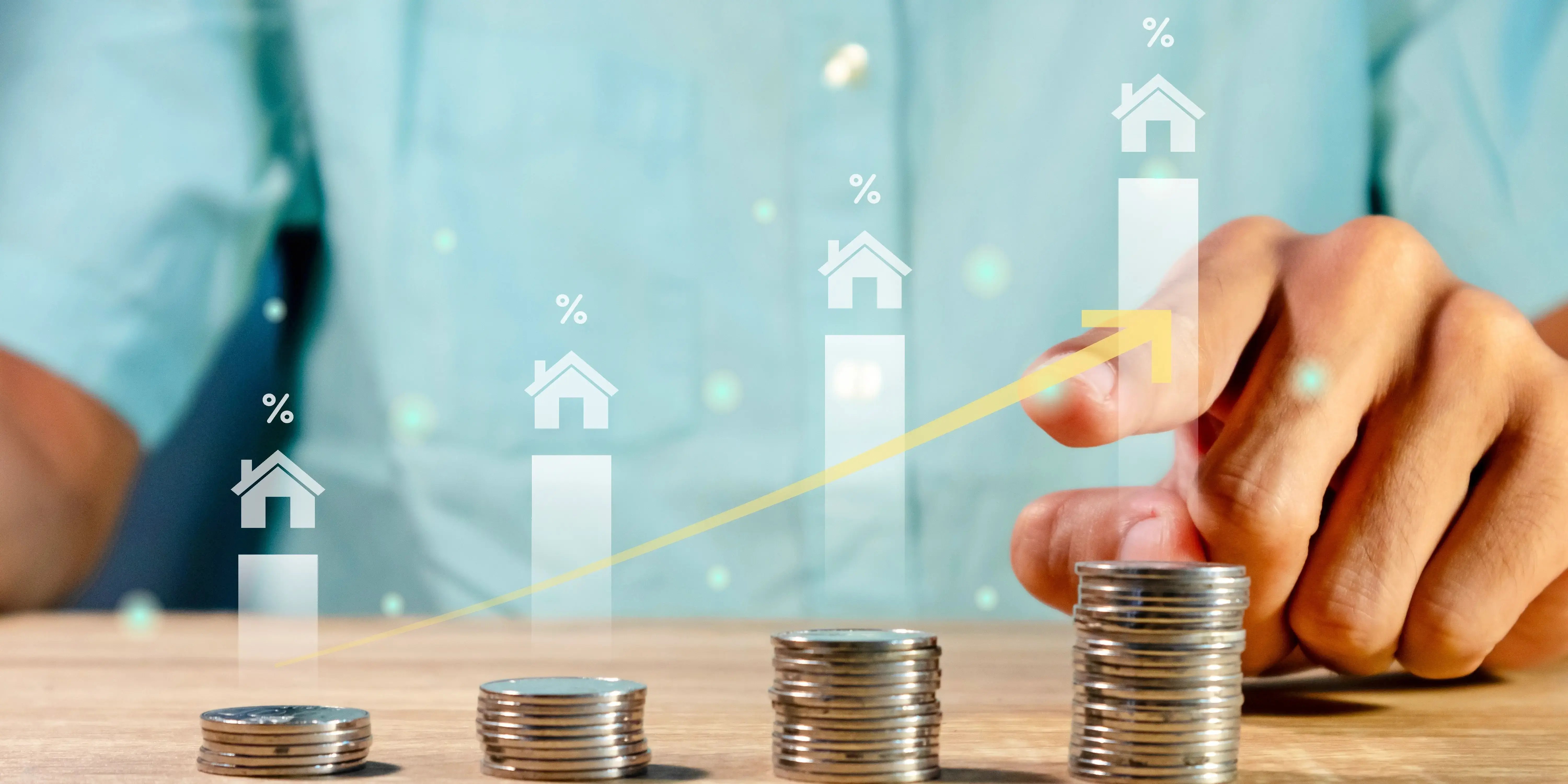 Hombre con unas torres de monedas en la mesa y gráficas que van en aumento gracias a la plusvalía