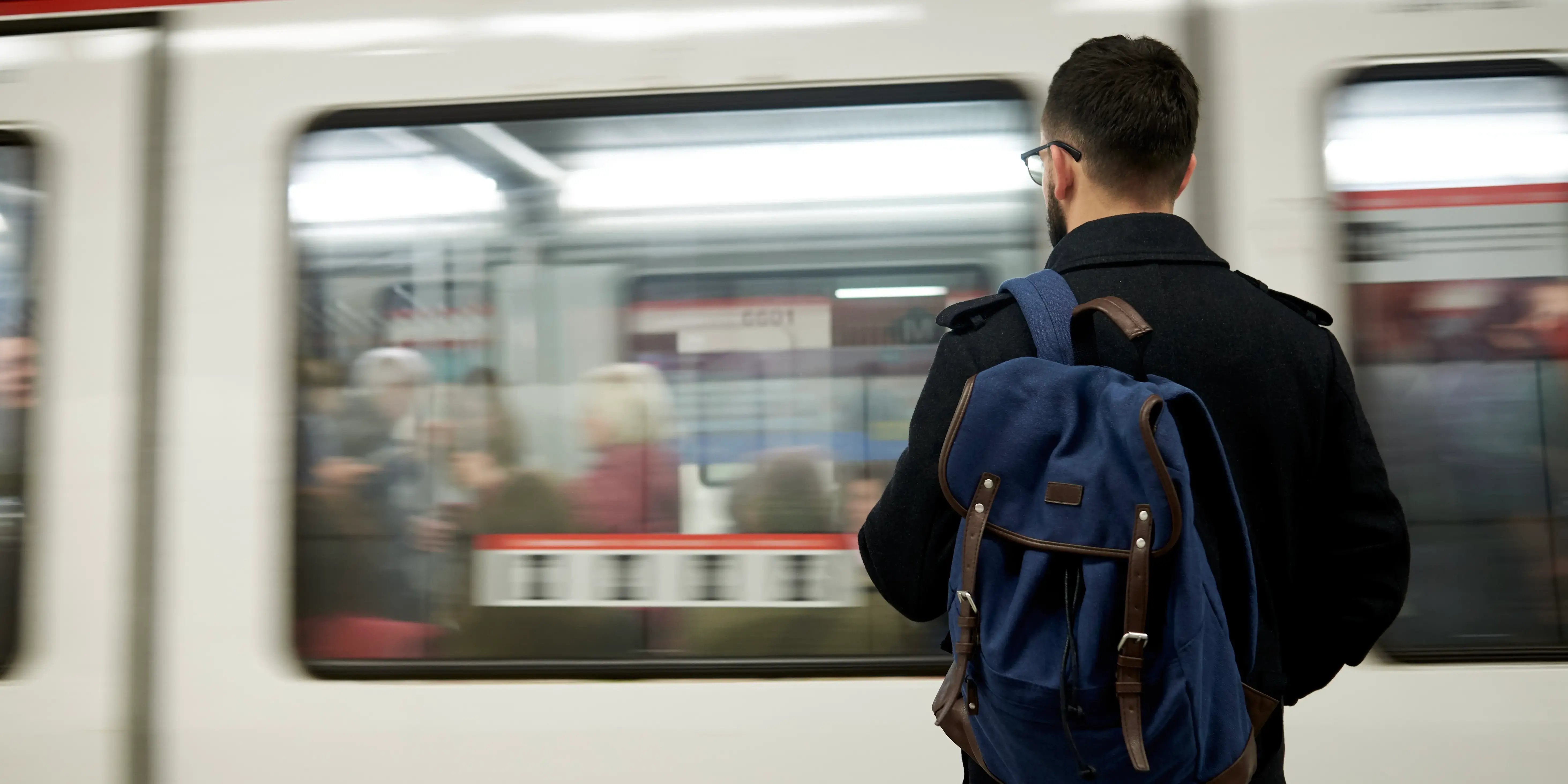Joven que vive cerca del transporte público está parado frente al tren del metro