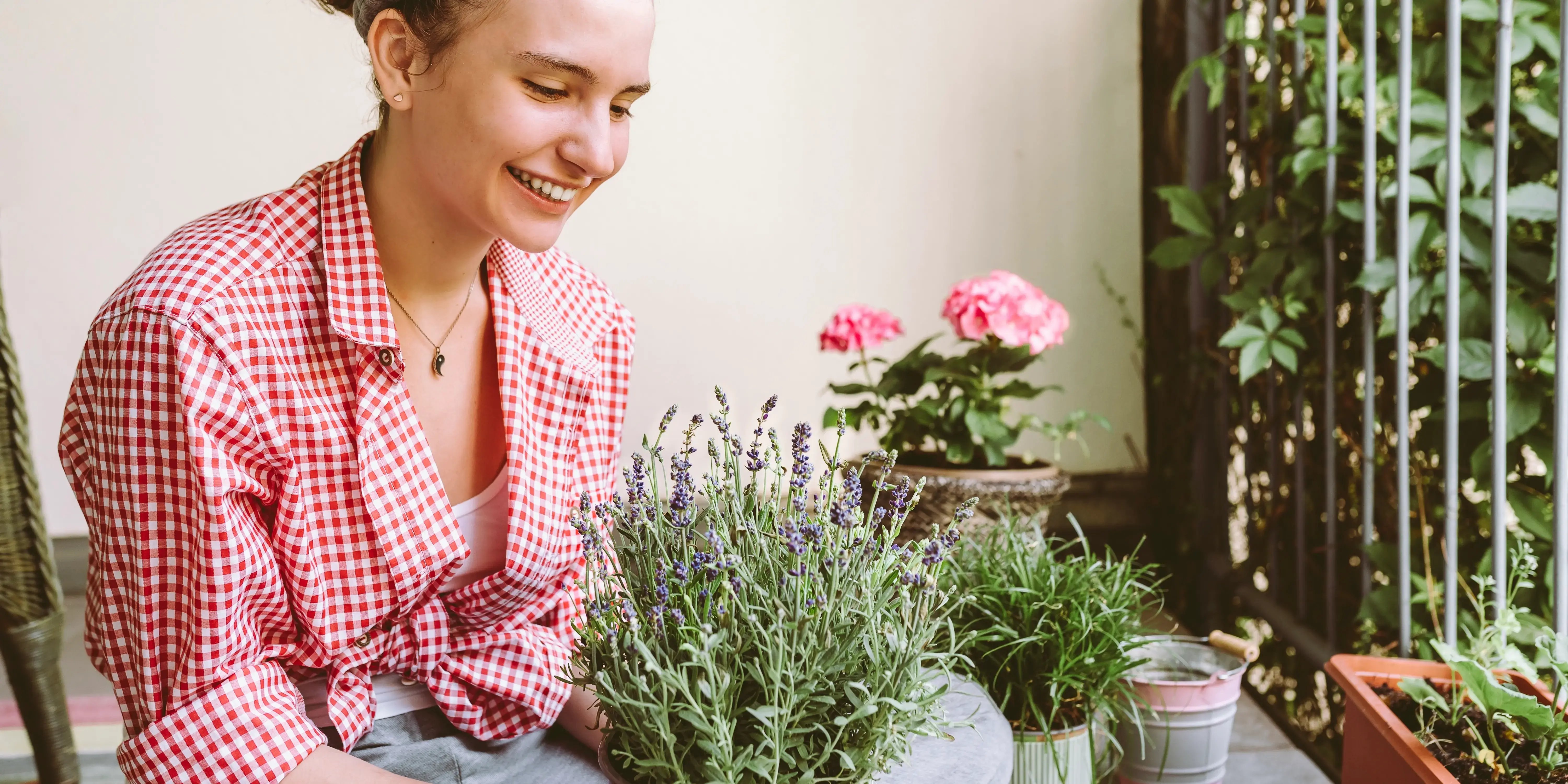 Mujer creando un rincón verde en el balcón de su casa para tener un hogar saludable