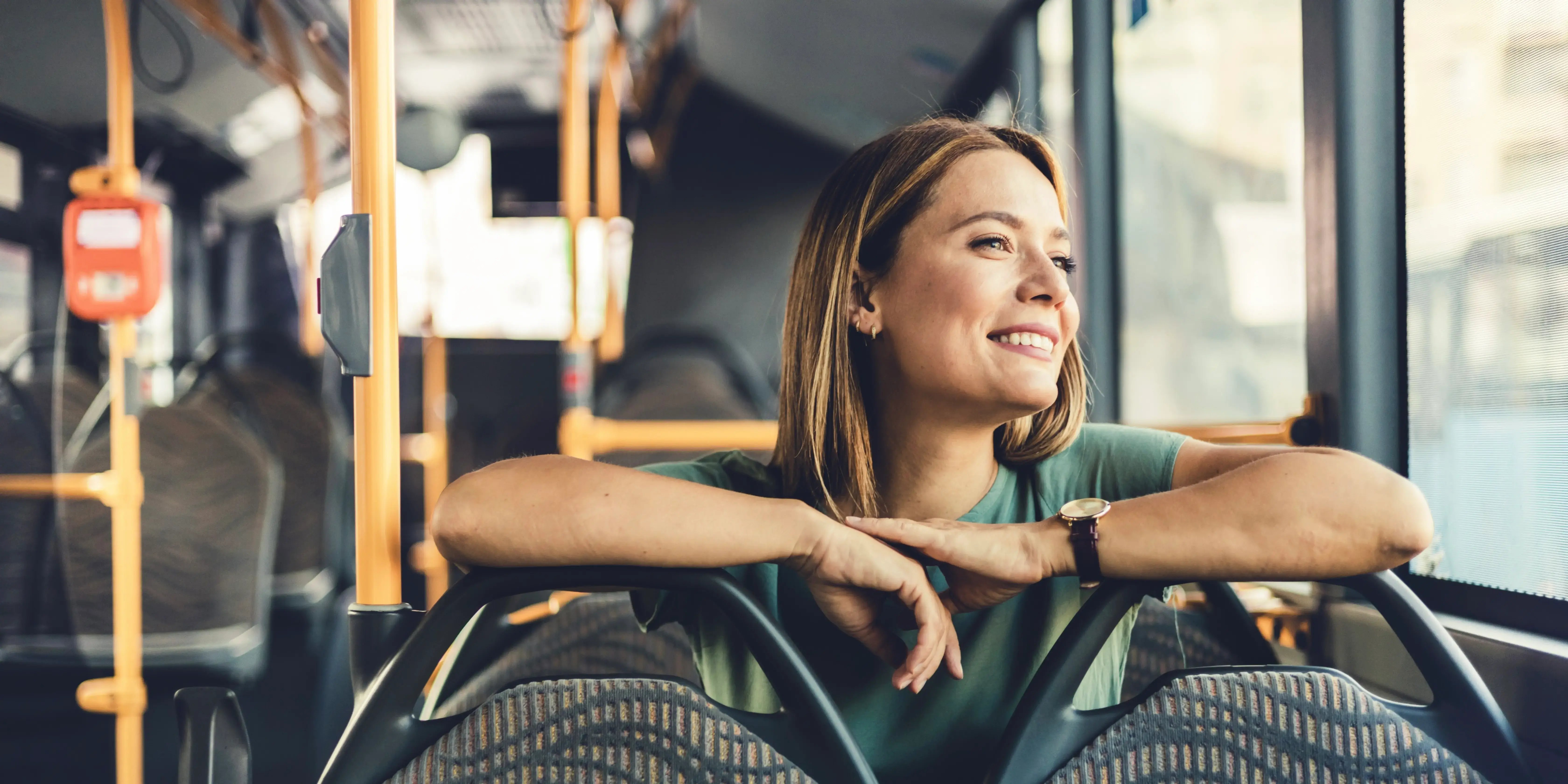 Mujer joven viajando con transporte público sentada relajada pues vive cerca del trasnporte público y ahorra tiempo en traslados