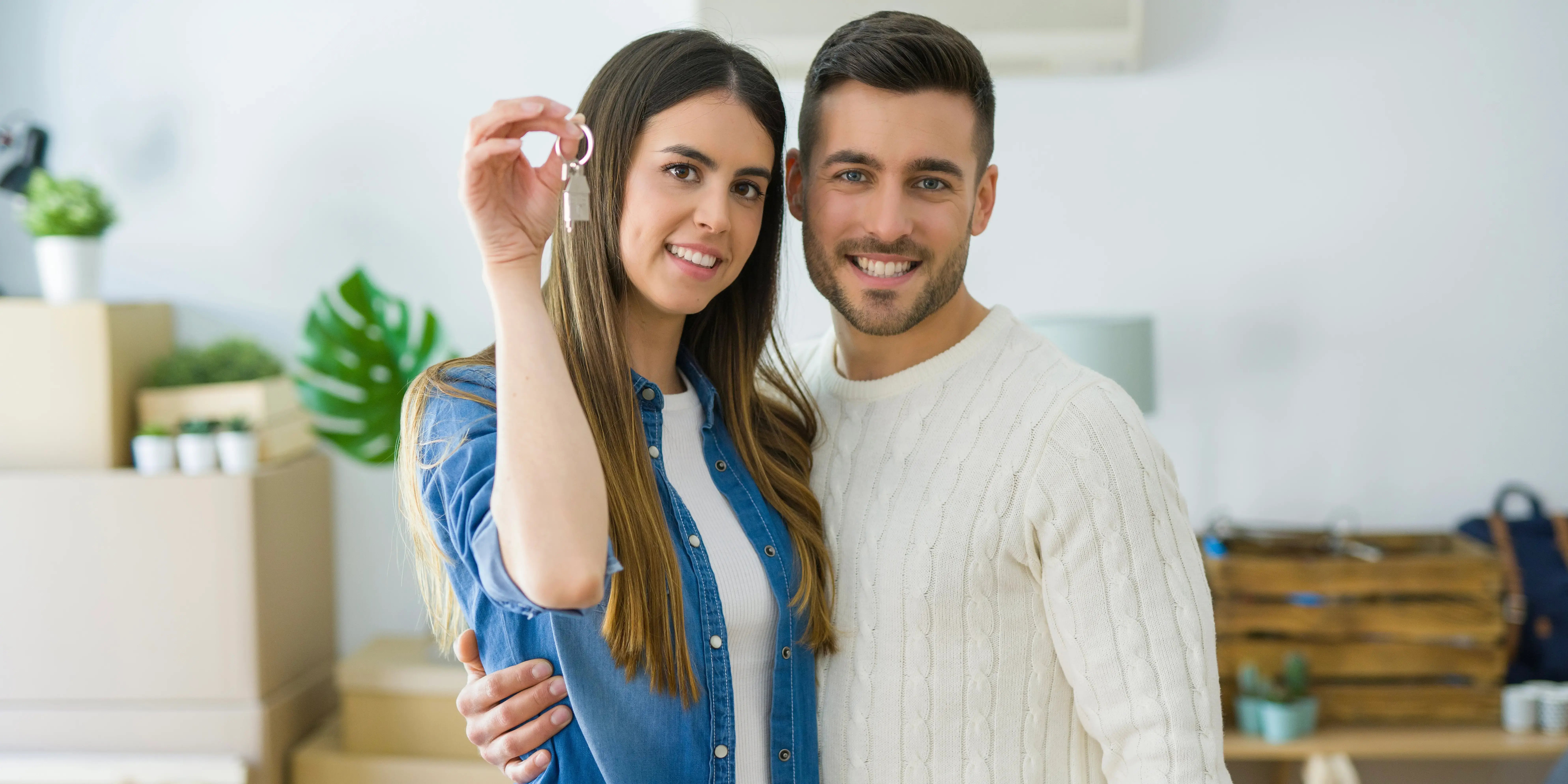 Pareja feliz sosteniendo las llaves de la casa que acaban de comprar
