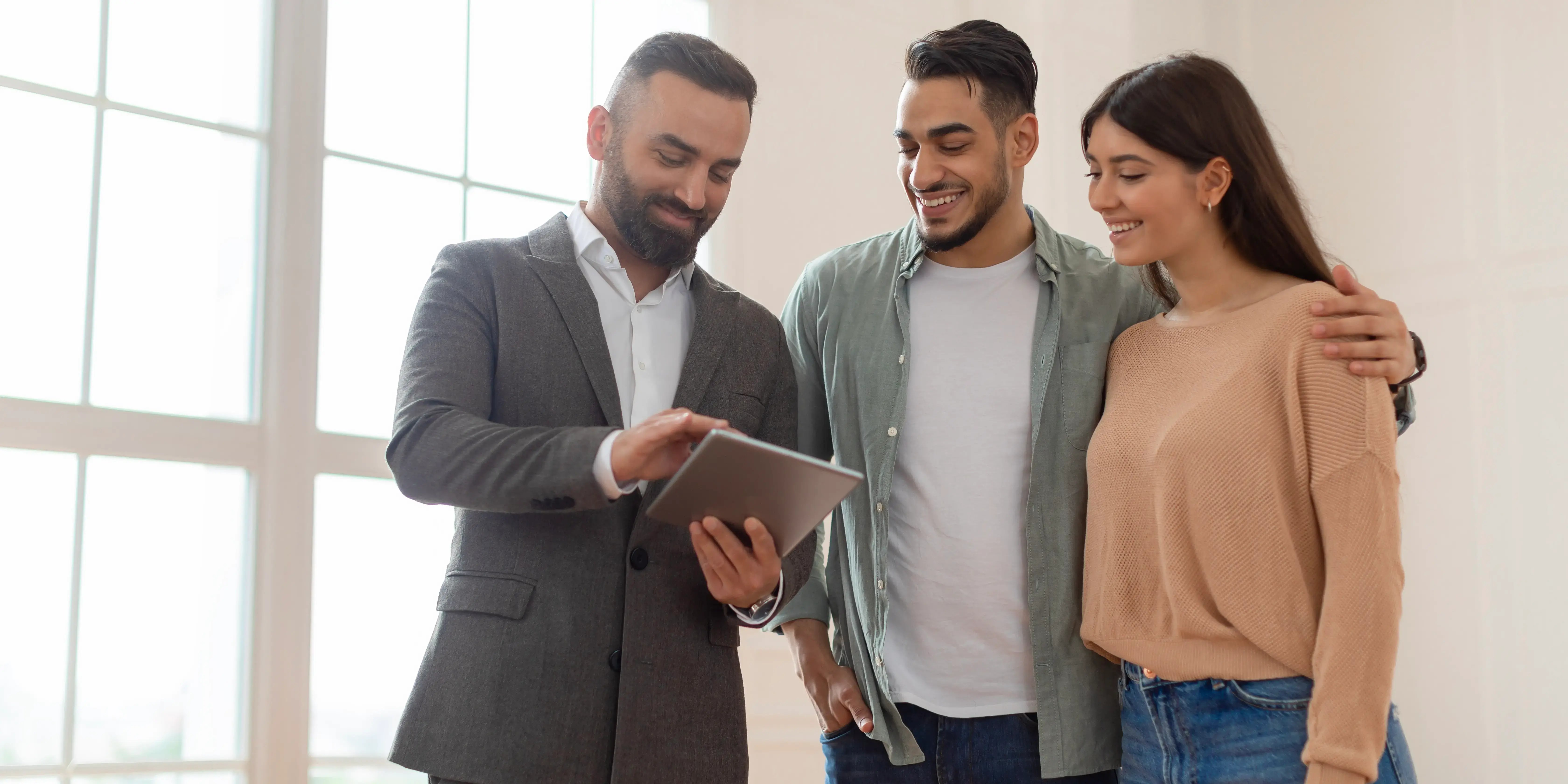 Pareja preguntando a asesor inmobiliario los beneficios extras de las promociones inmobiliarias