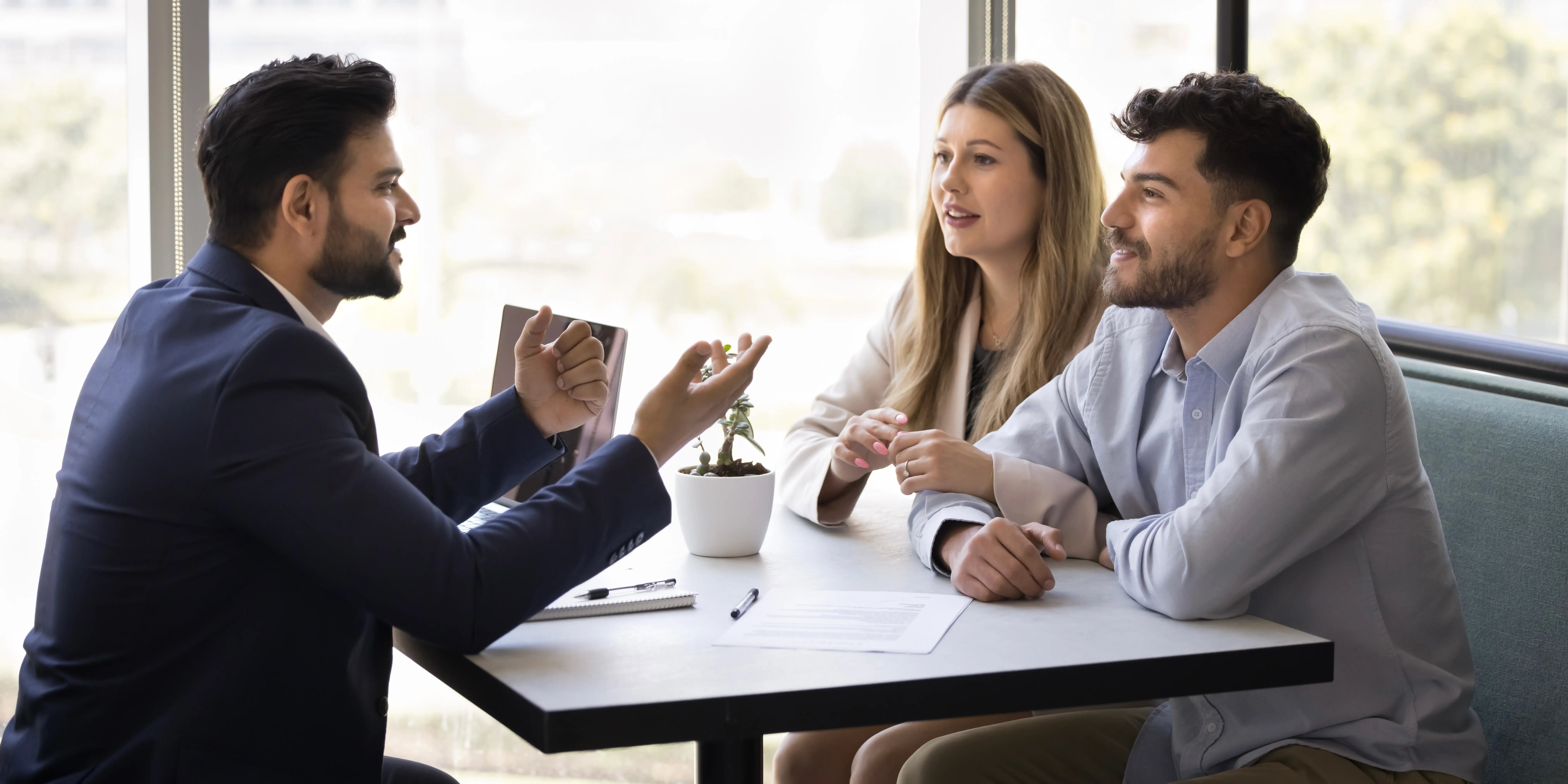 Pareja que consulta a experto financiero, agente inmobiliario en la reunión los mecanismos de financiamiento accesibles, créditos y subsidios para una vivienda adecuada