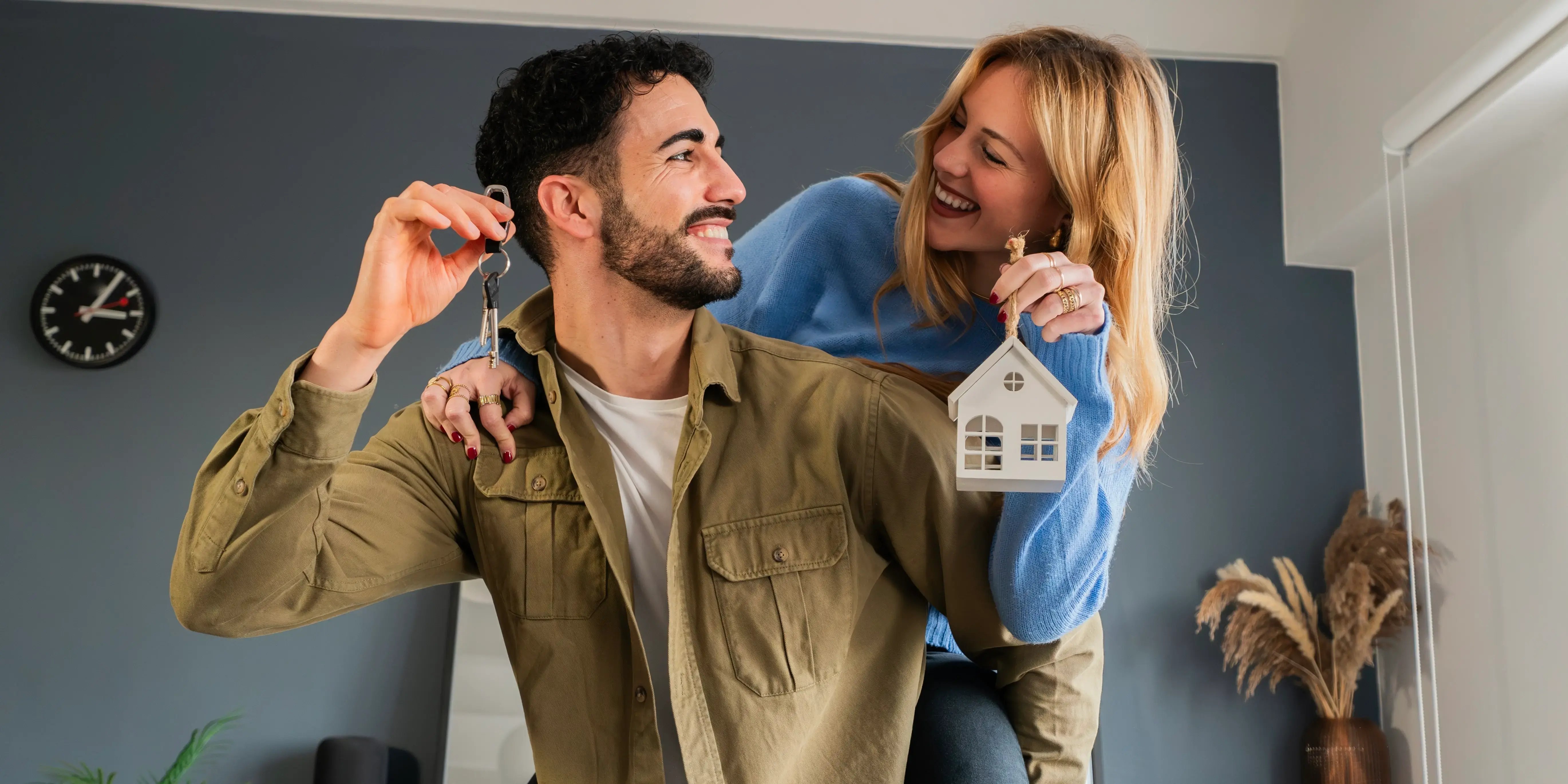 Pareja sonriendo y sosteniendo las llaves de su nueva casa que compraron sin crédito Infonavit-2
