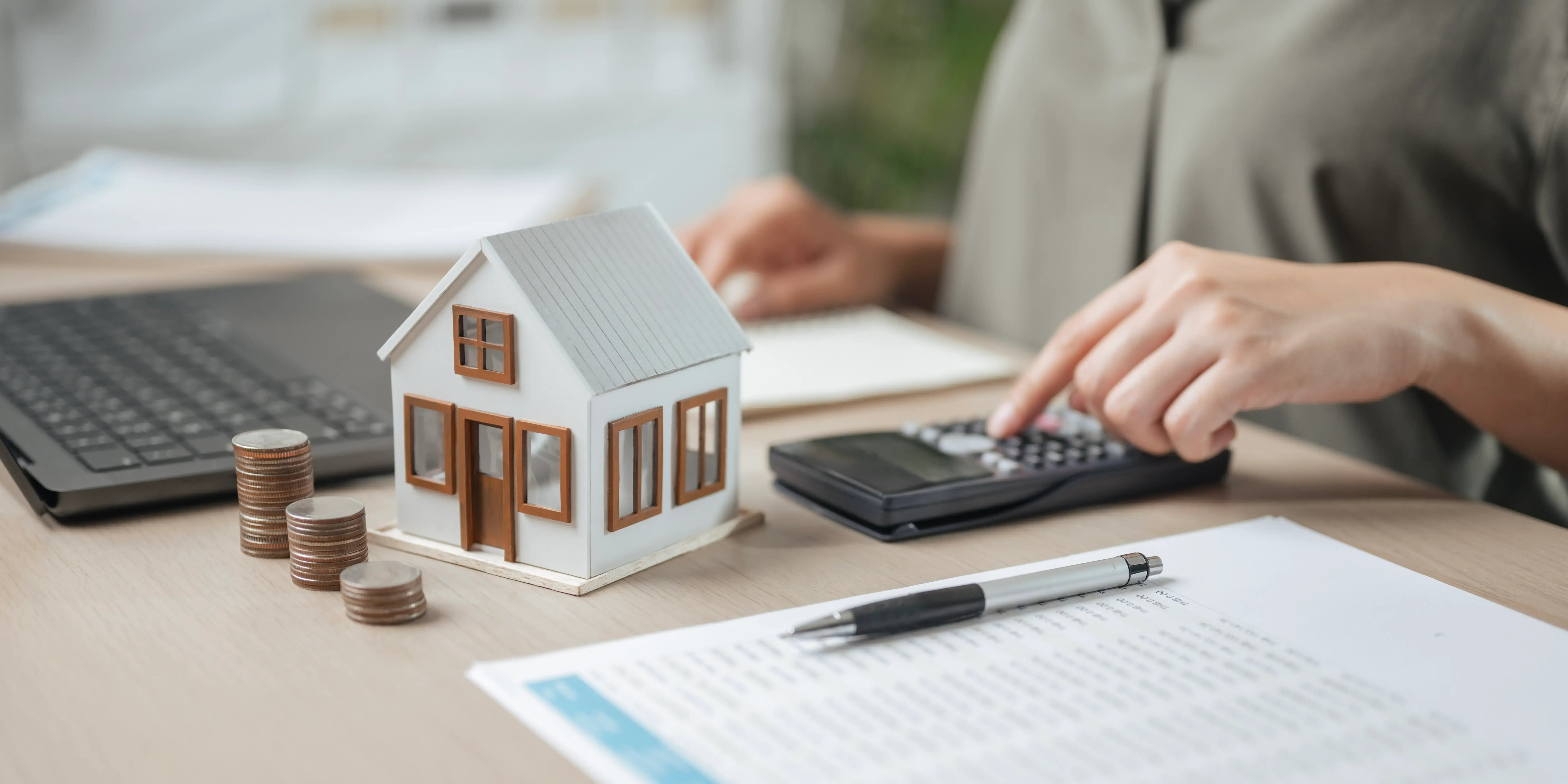 Persona con una calculadora y unos documentos viendo cuánto cuesta escriturar una casa