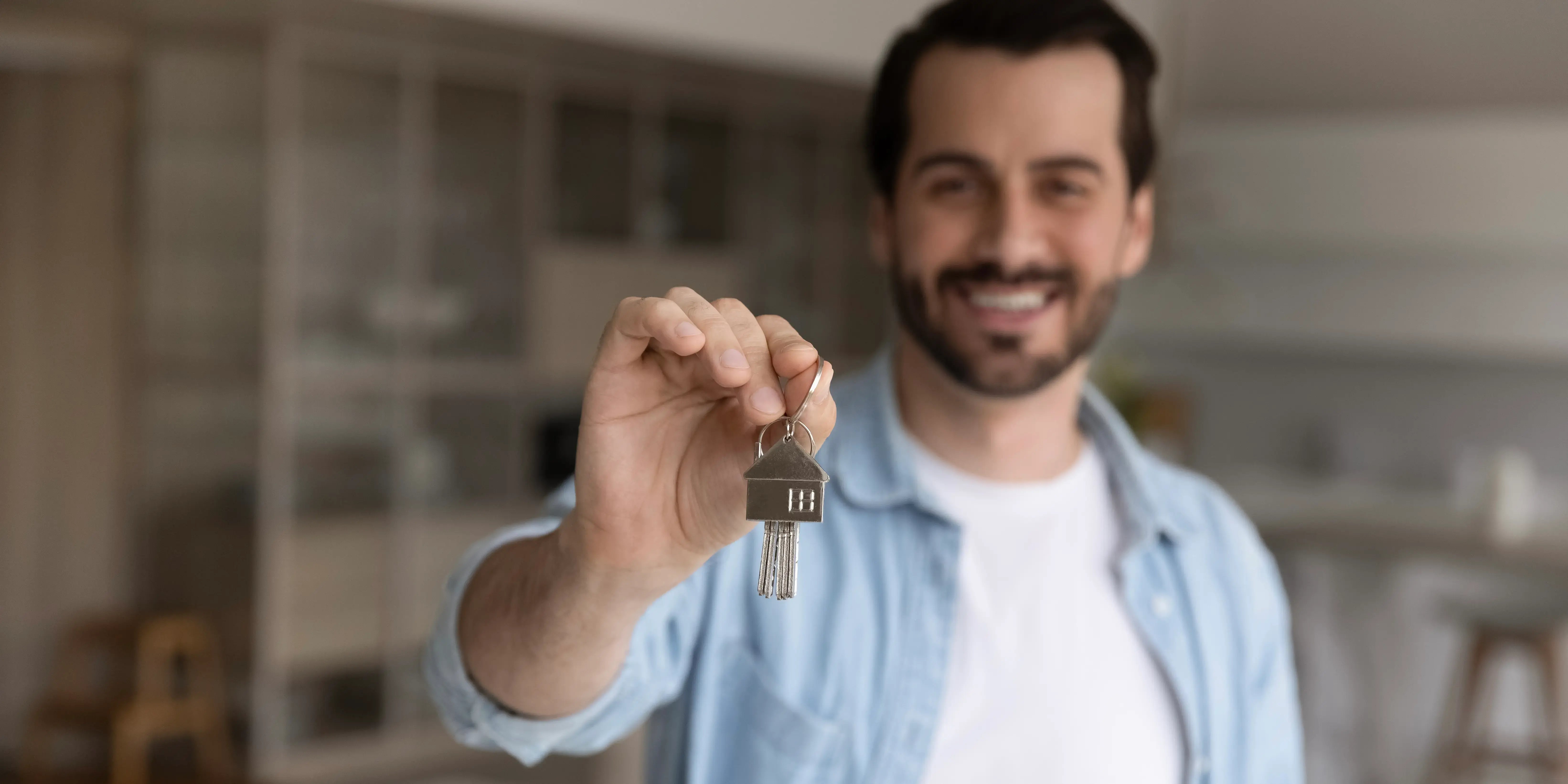 Un hombre sonriente se siente emocionado porque acaba de comprar una casa
