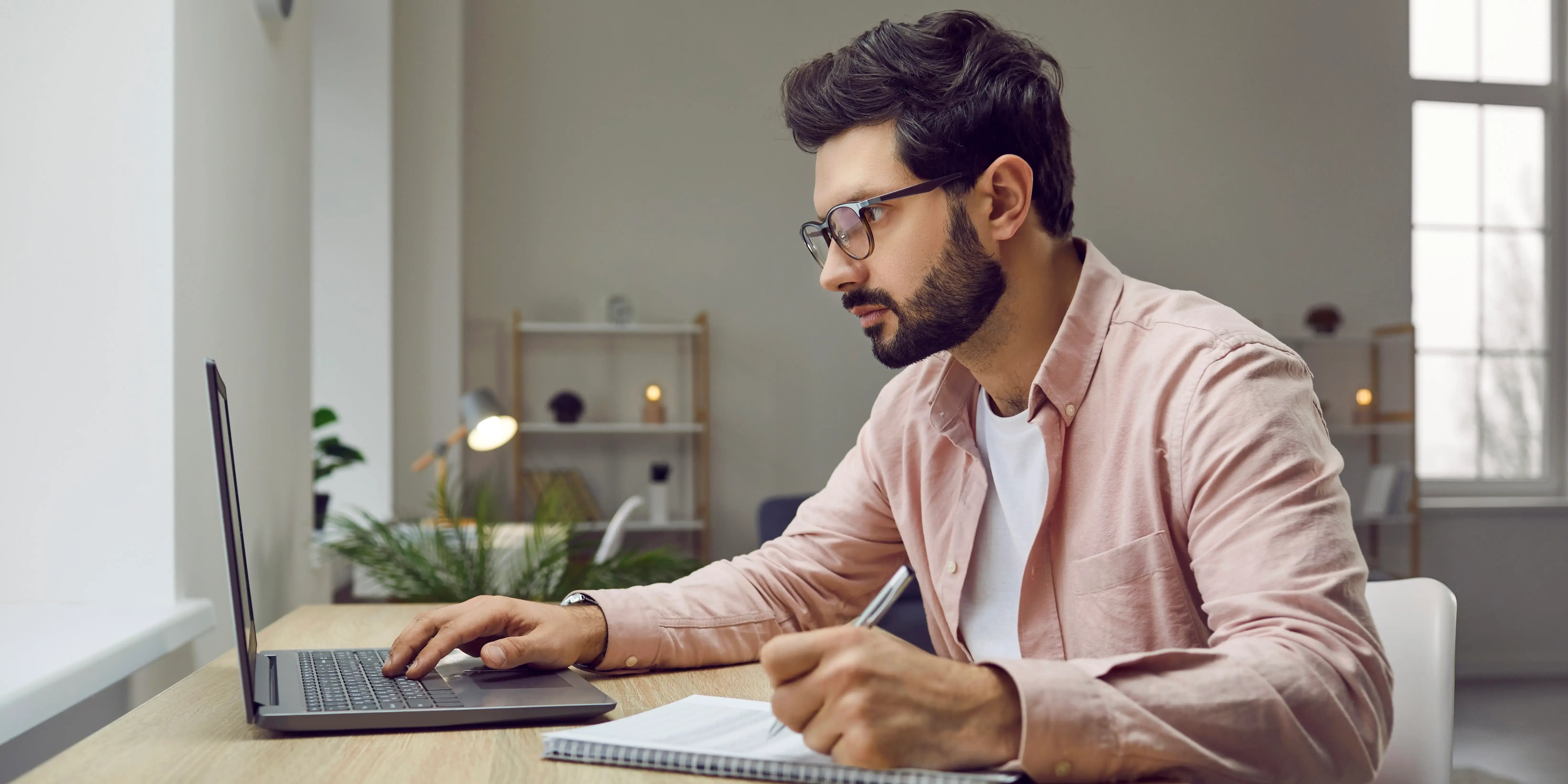 Un joven con gafas usando una laptop sacando la hoja de retención Infonavit