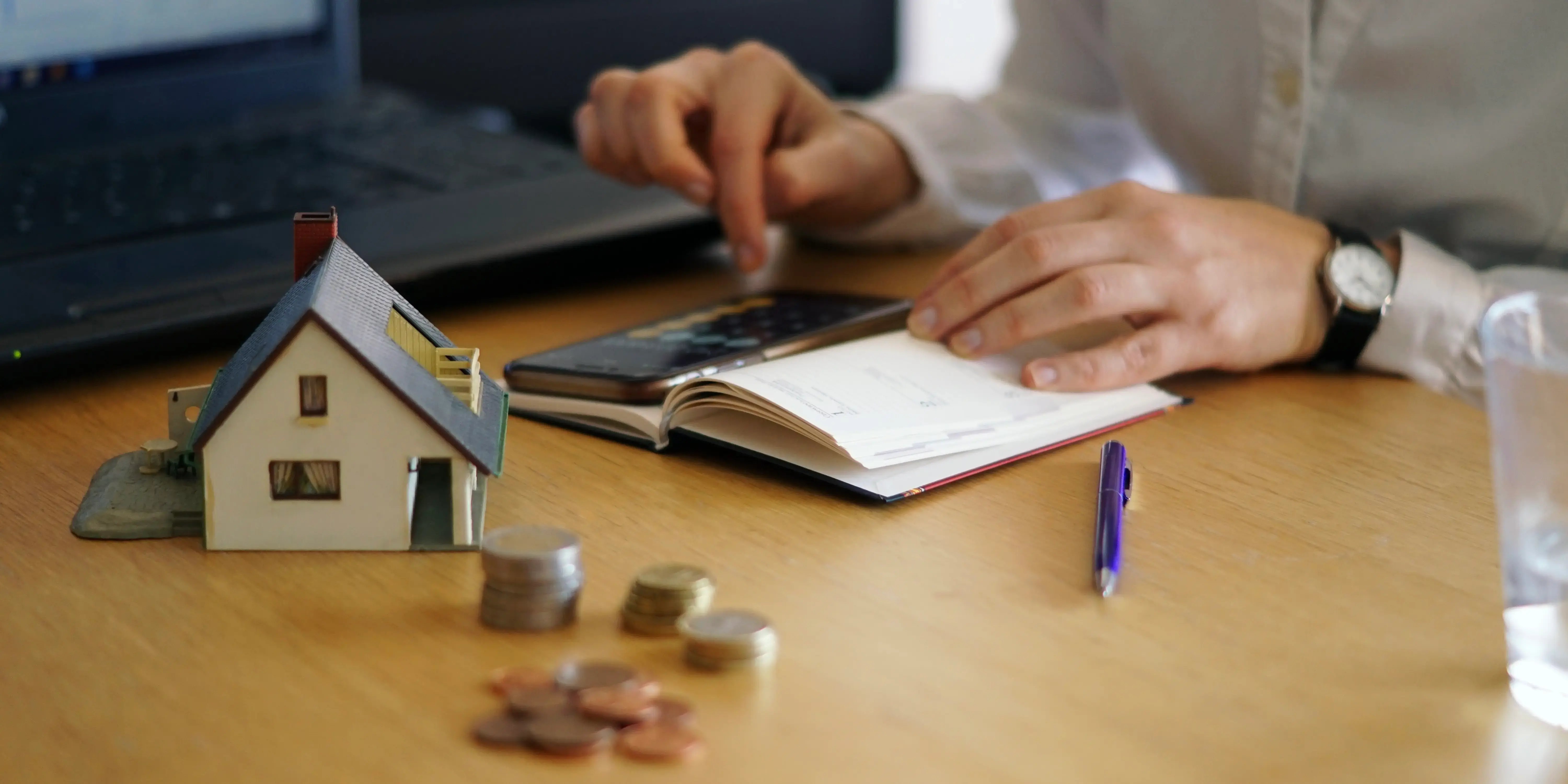 Persona haciendo cuentas en una calculadora. Invertir en una casa durante la incertidumbre económica