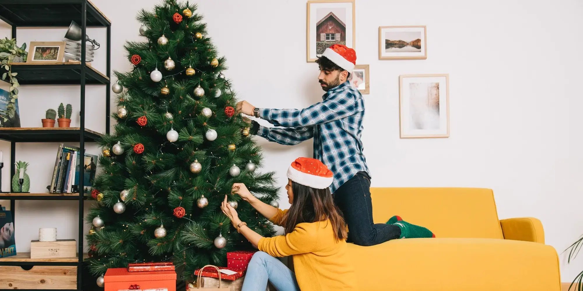 Pareja decorando un árbol. Navidad en tu nueva casa