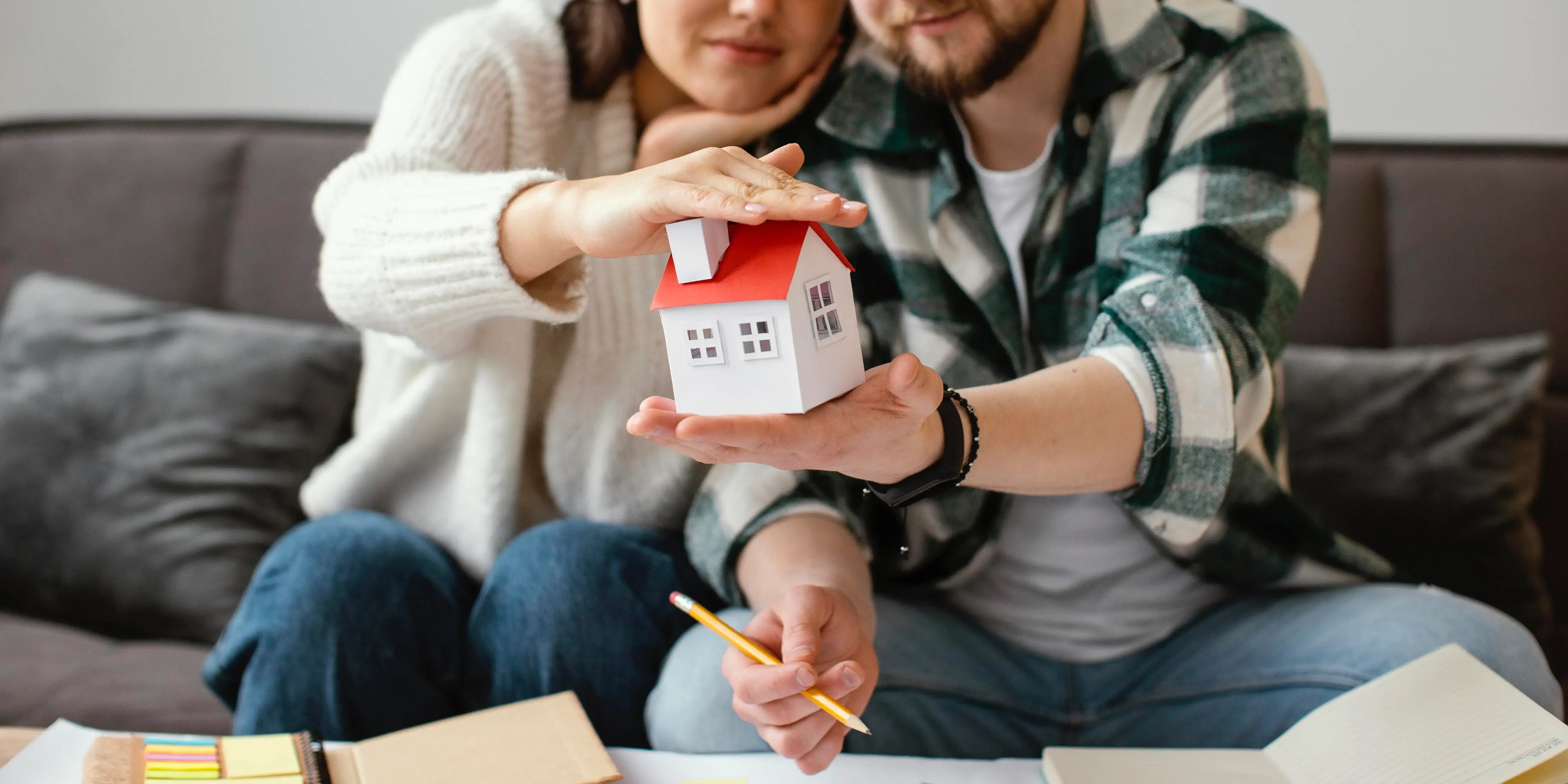 Manos sosteniendo una casita. Qué son las finanzas