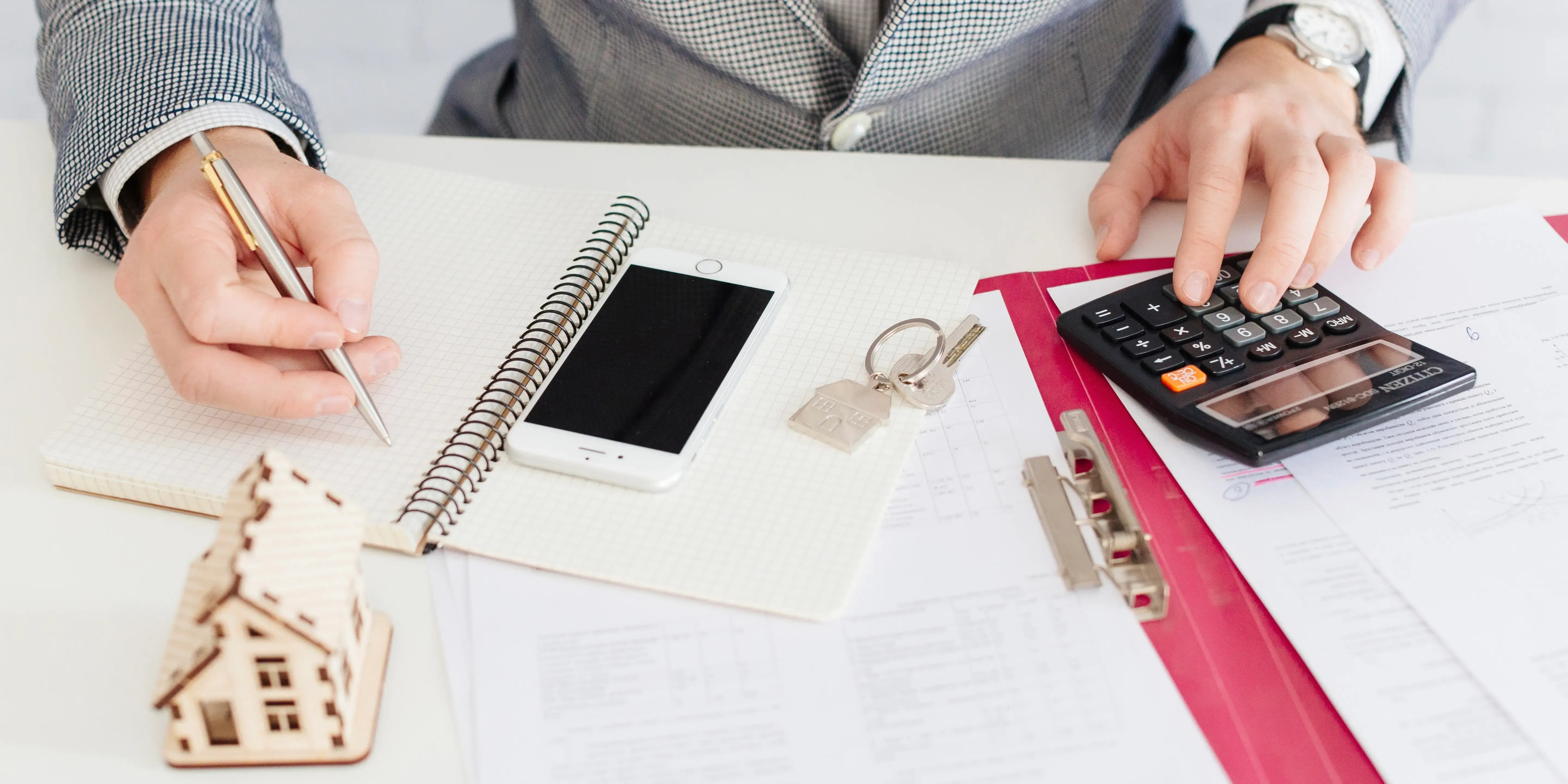 Hombre con calculadora y libreta comparando. Errores al solicitar tu crédito hipotecario