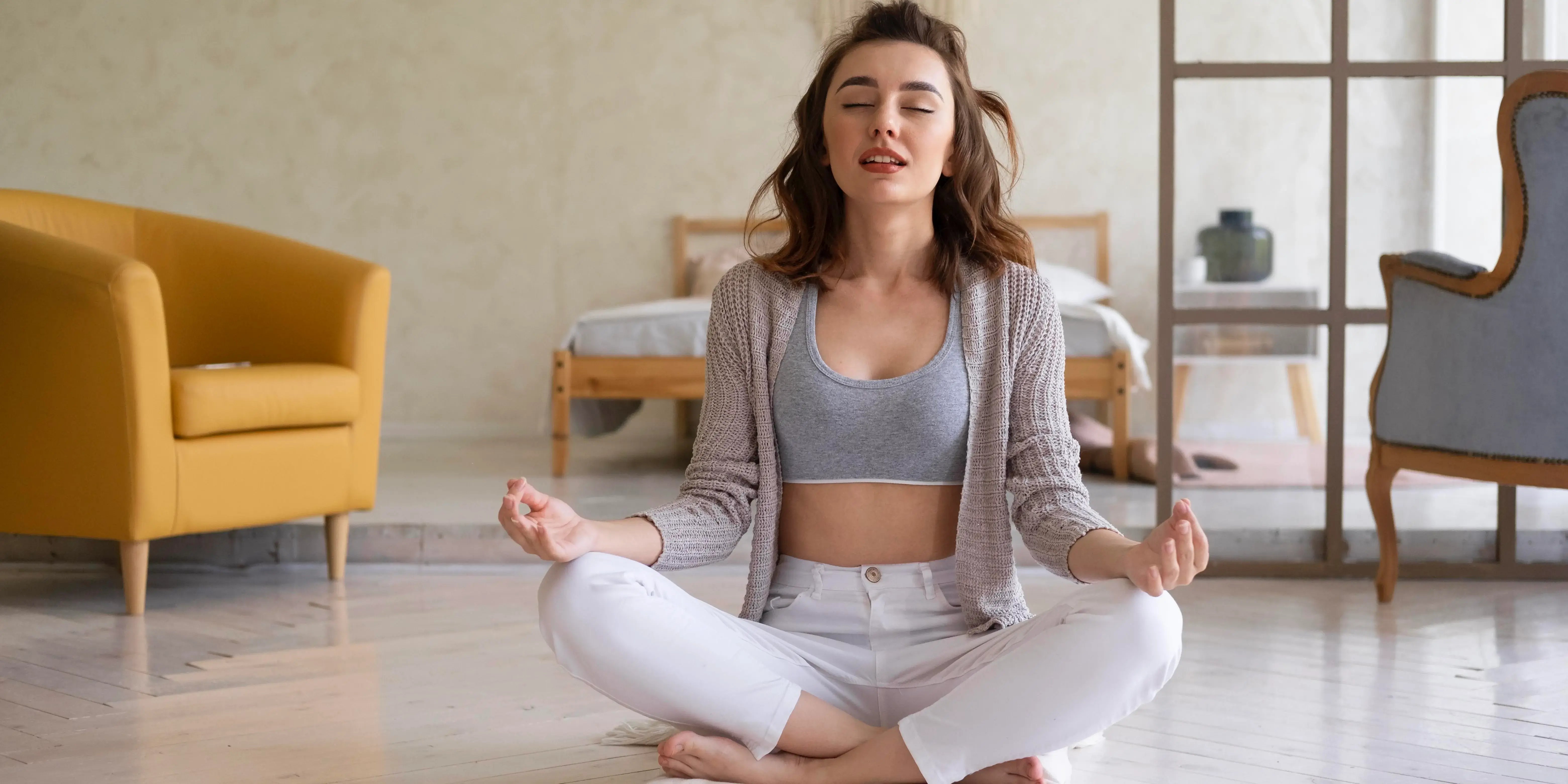 Mujer meditando en la sala de su casa. Habitos de vida saludable