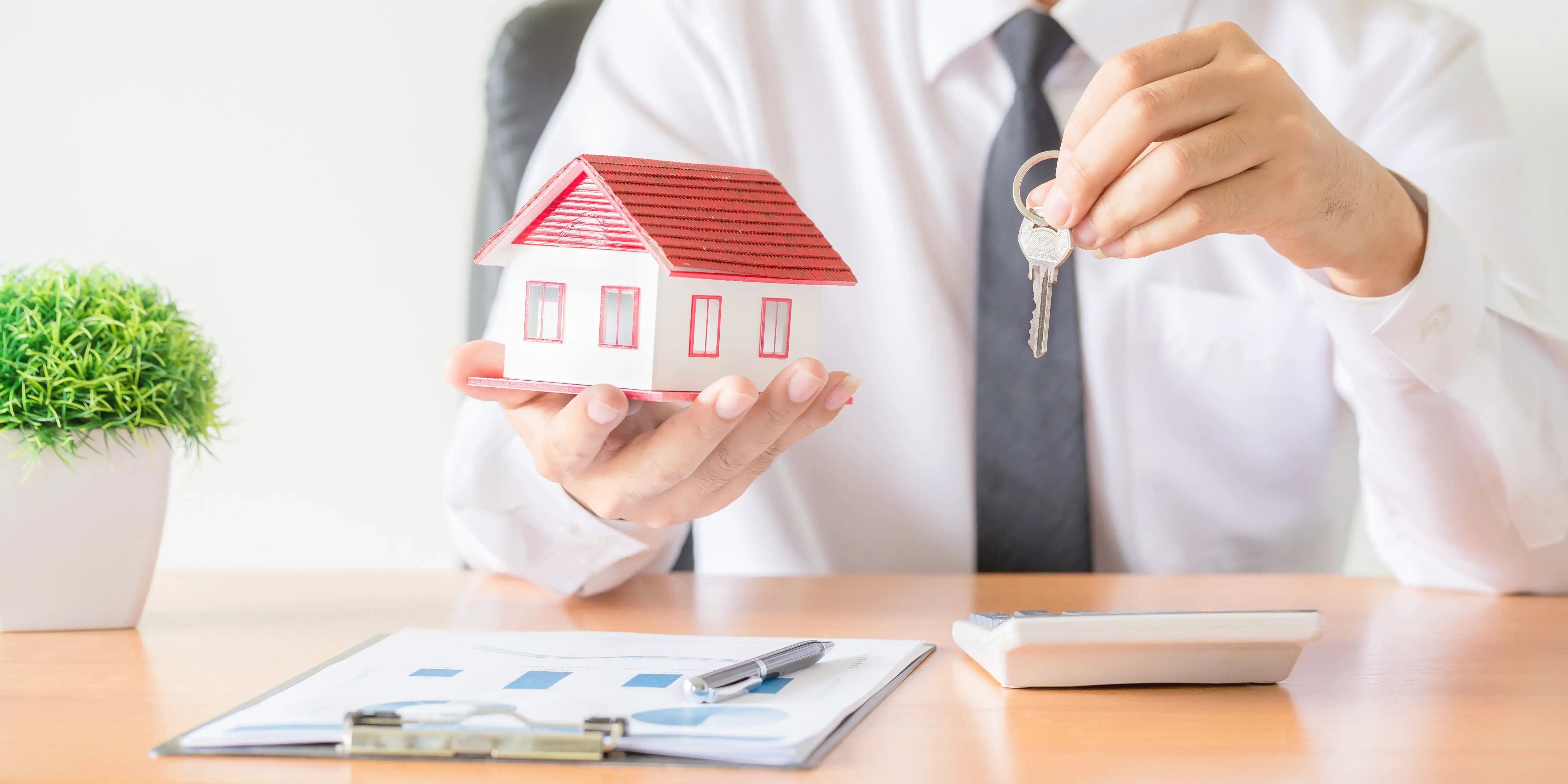 Hombre sosteniendo casa y llaves. Plusvalía