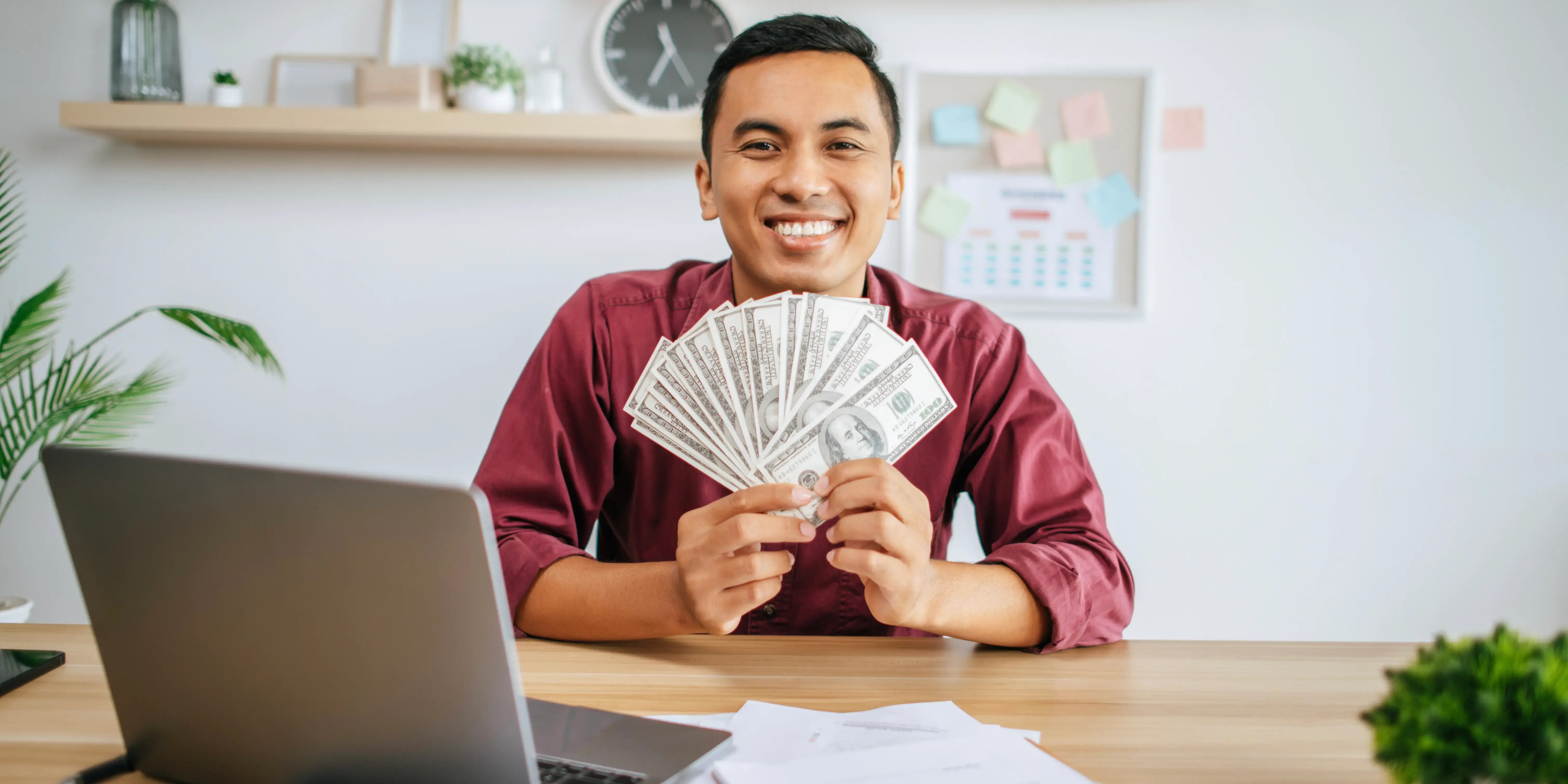 Hombre en escritorio con dinero. en que puedo invertir mi dinero para multiplicarlo