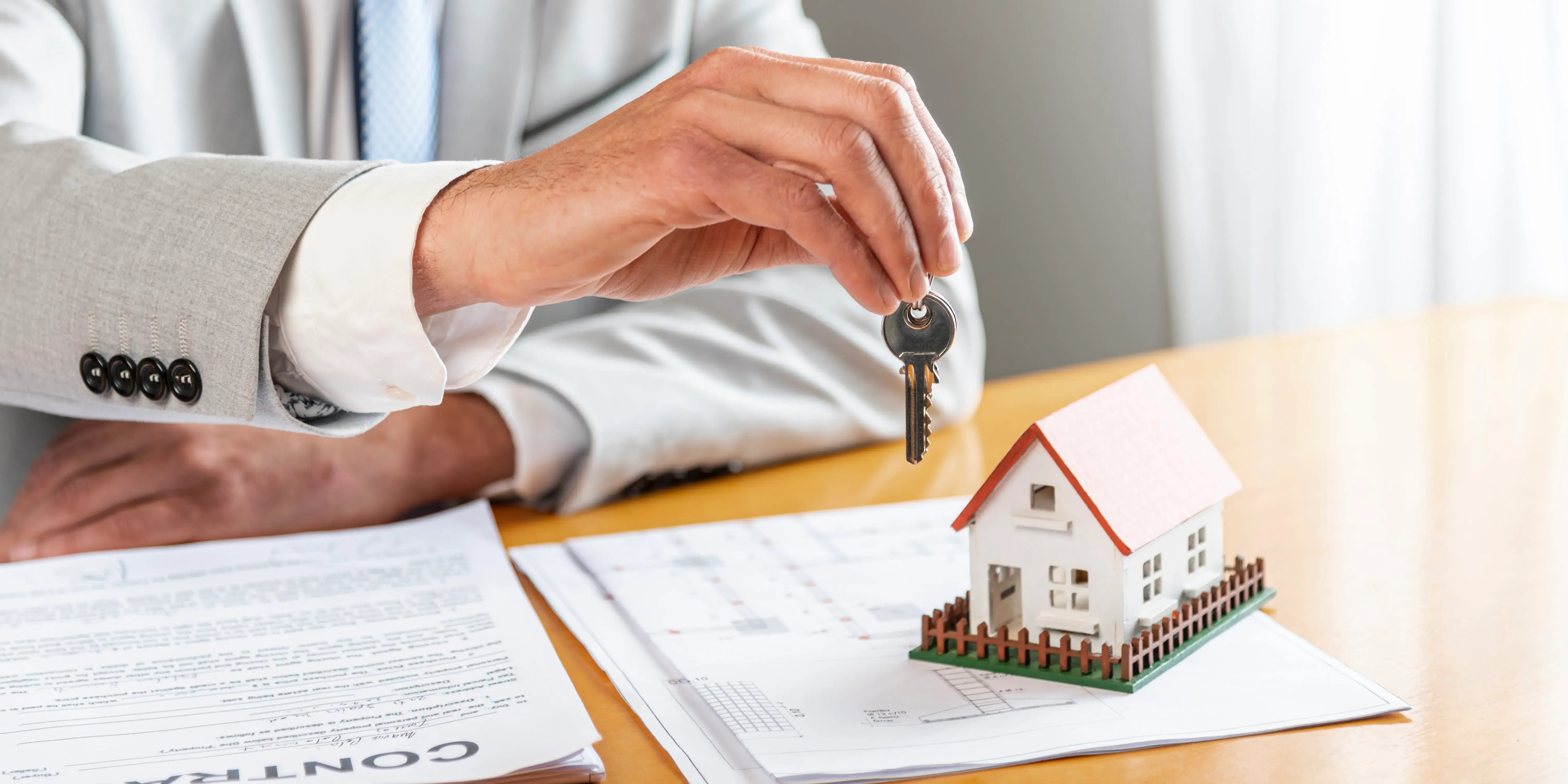 Manos sosteniendo llaves de una casa. Inversiones seguras
