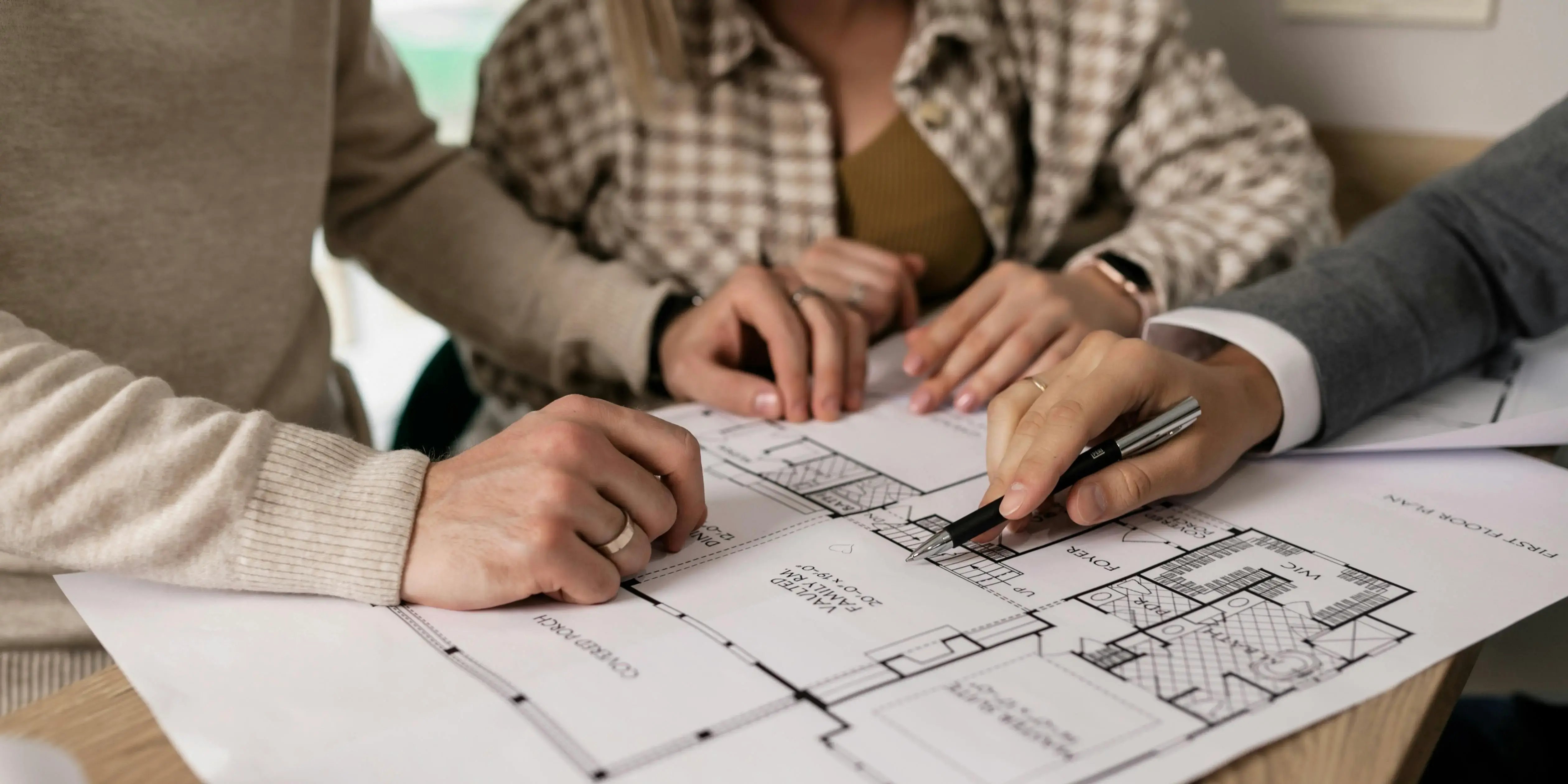 Bróker enseñándole planos de la casa a una pareja.Listo para estrenar casa.