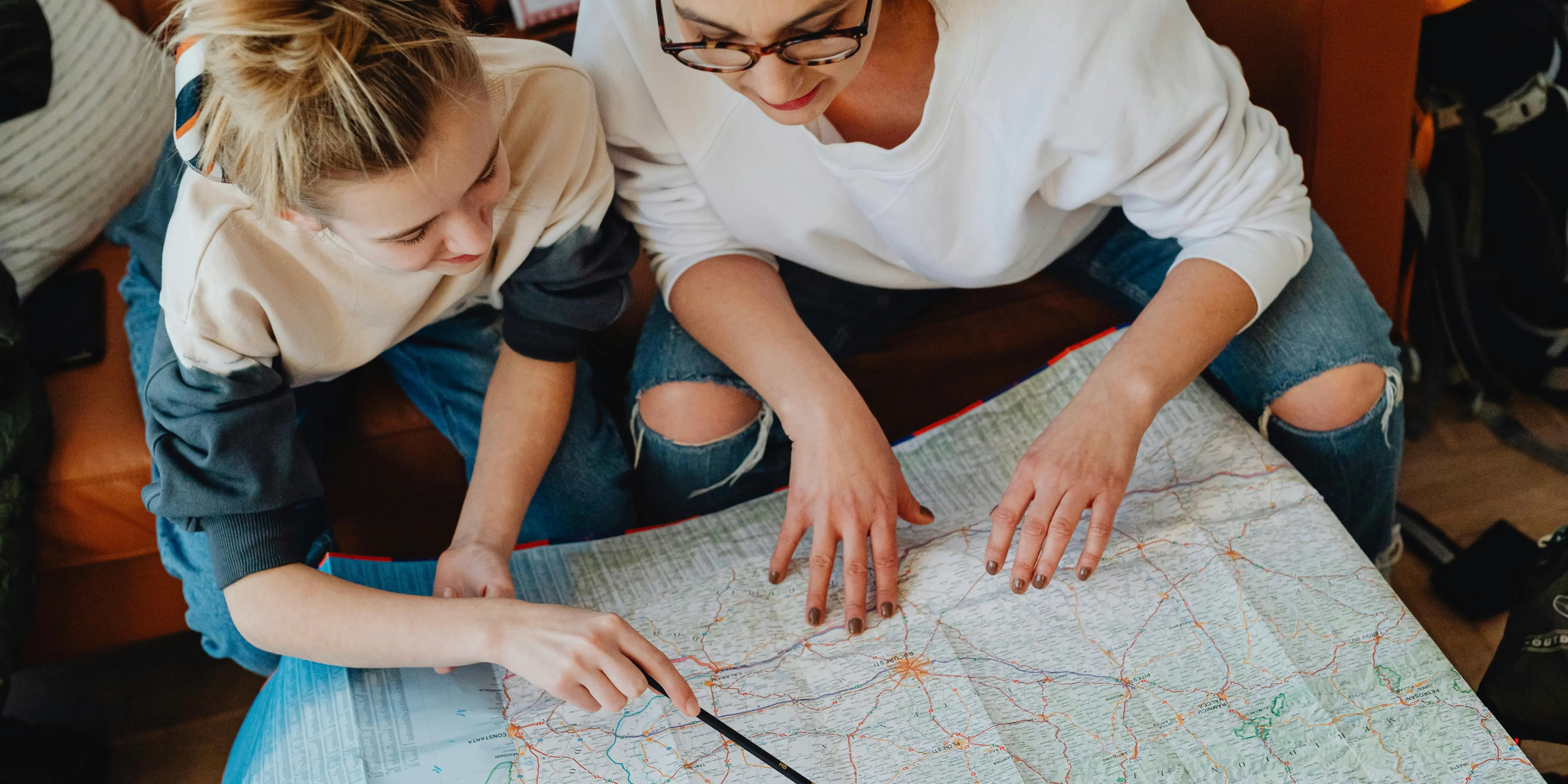 Mujeres viendo en mapa la ubicación de una casa.Tu primer hogar