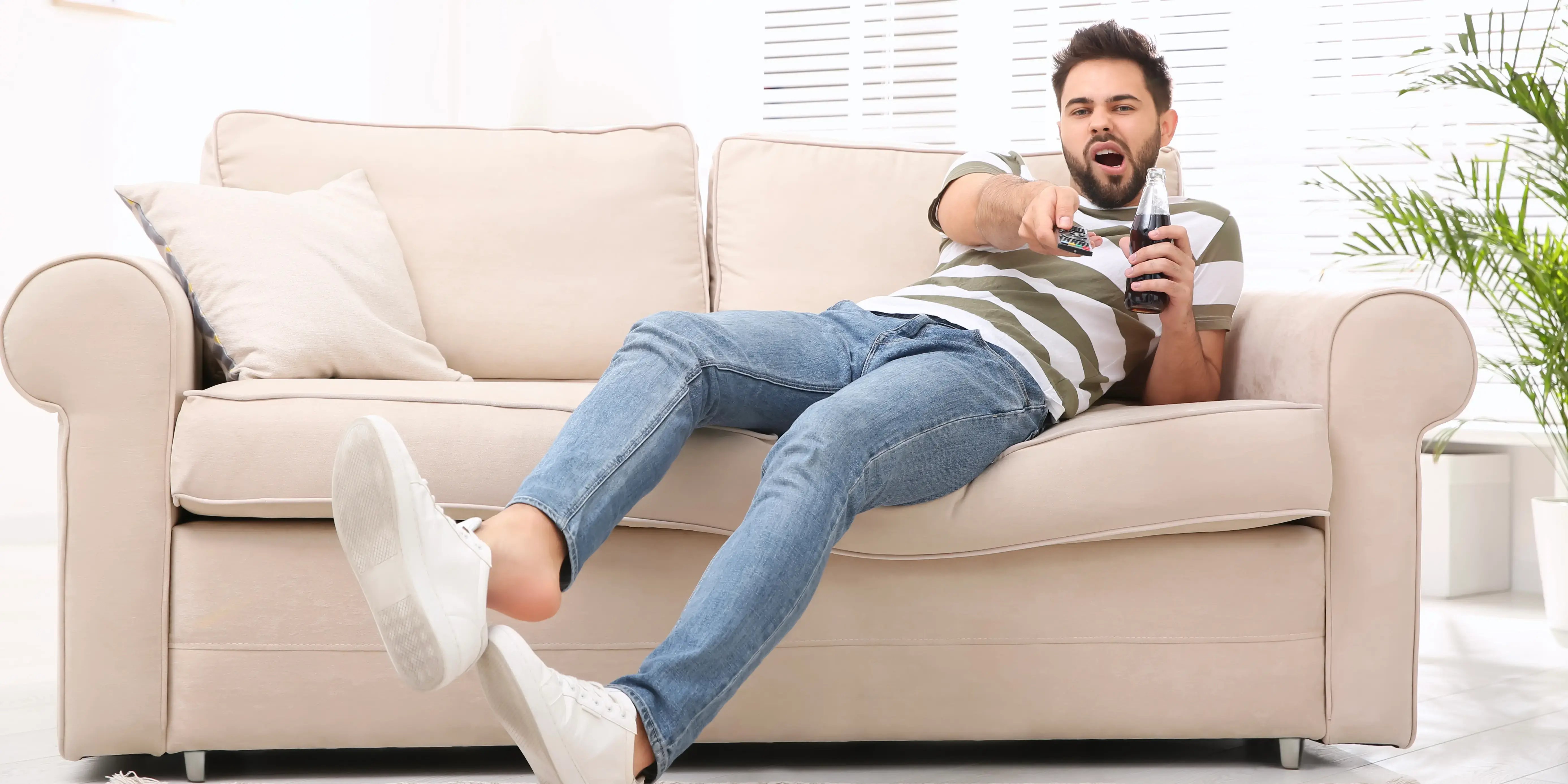 hombre en sillón con control remoto. ¿qué es sedentarismo?