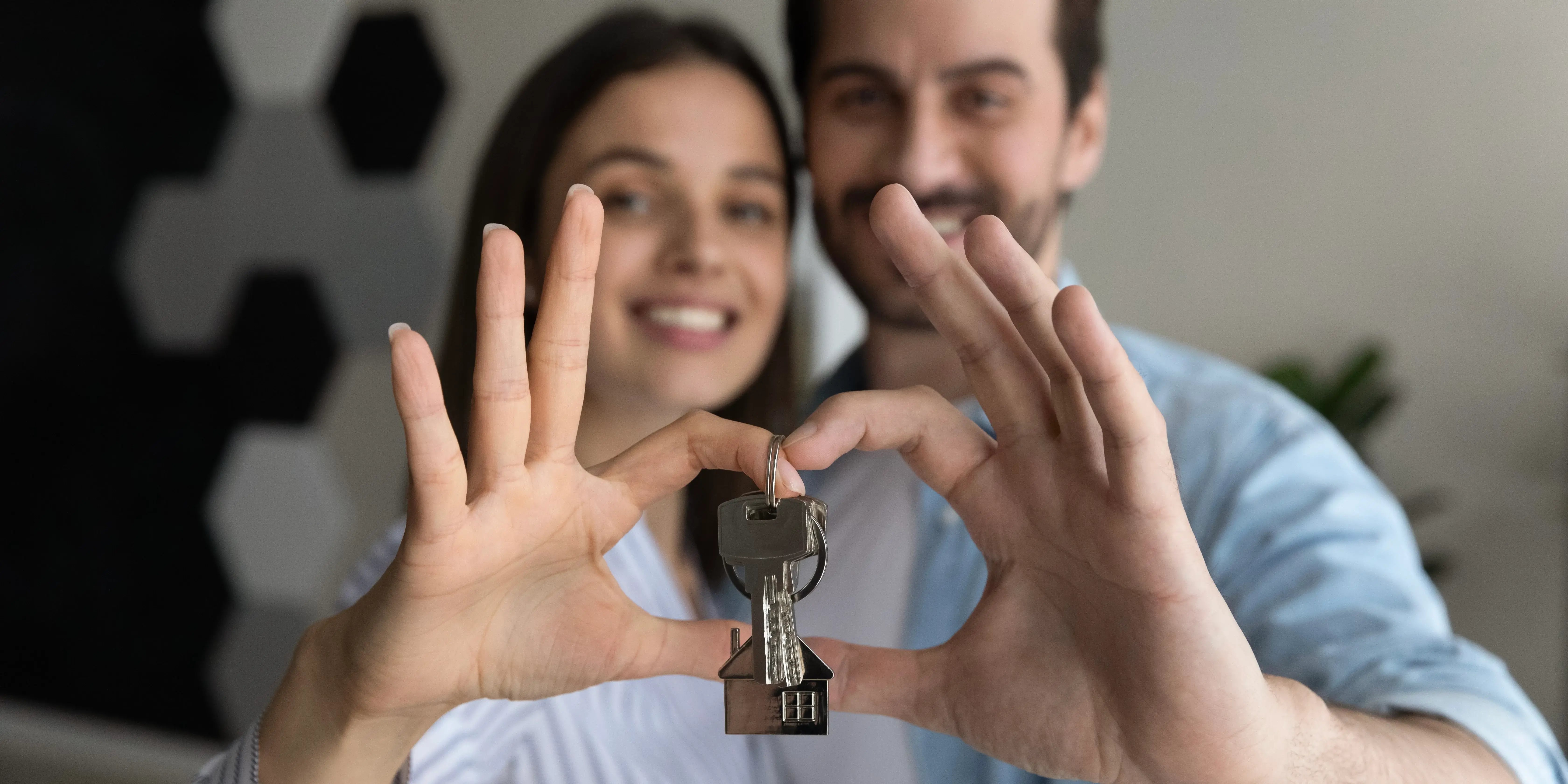 Pareja sosteniendo las llaves de su nueva casa.Comprar casa en 1015