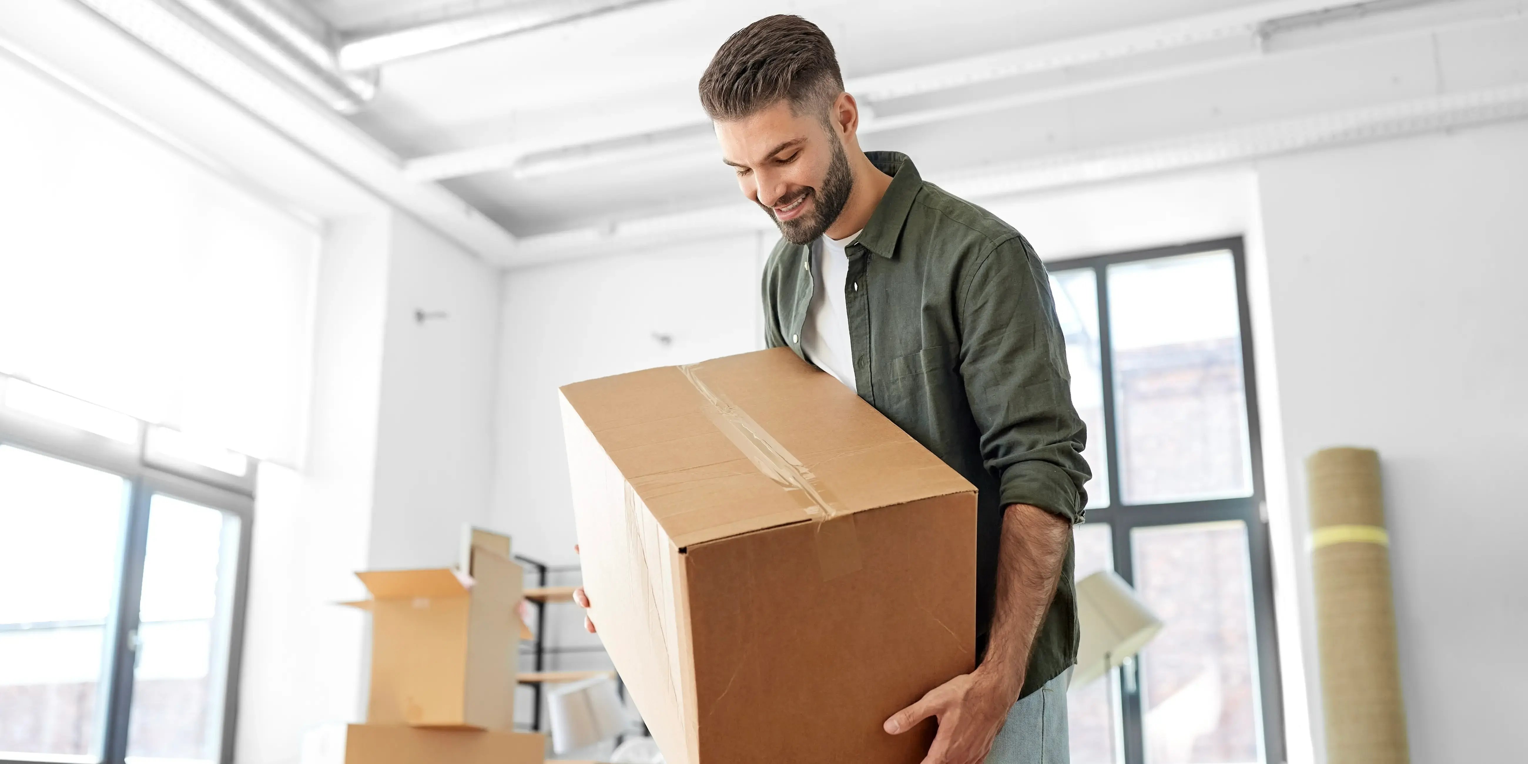 Hombre cargando caja de cartón. Consejos para mudarte sin estrés