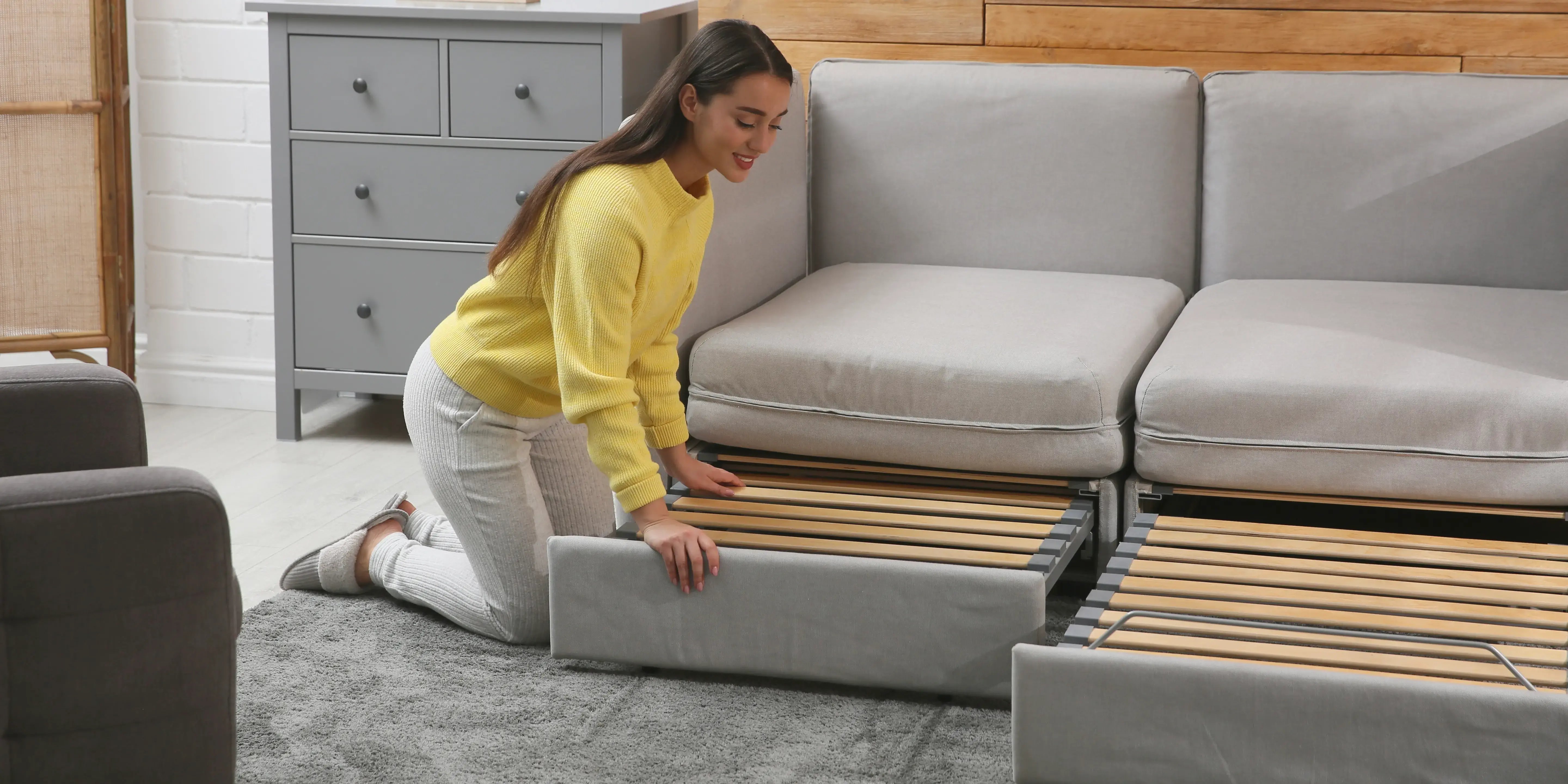 Mujer acomodando sofá cama. Decora sala pequeña