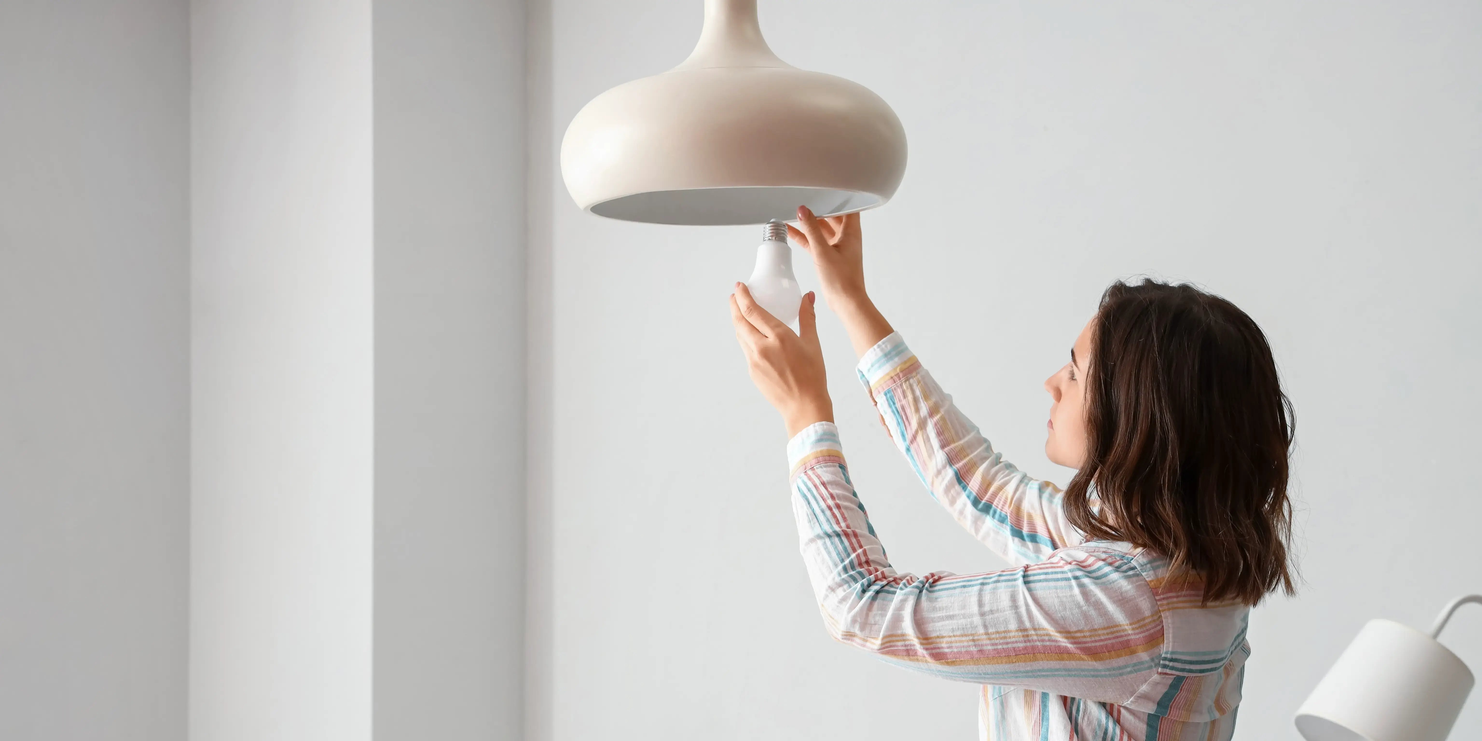 Mujer cambiando foco. decoración de interiores casas pequeñas