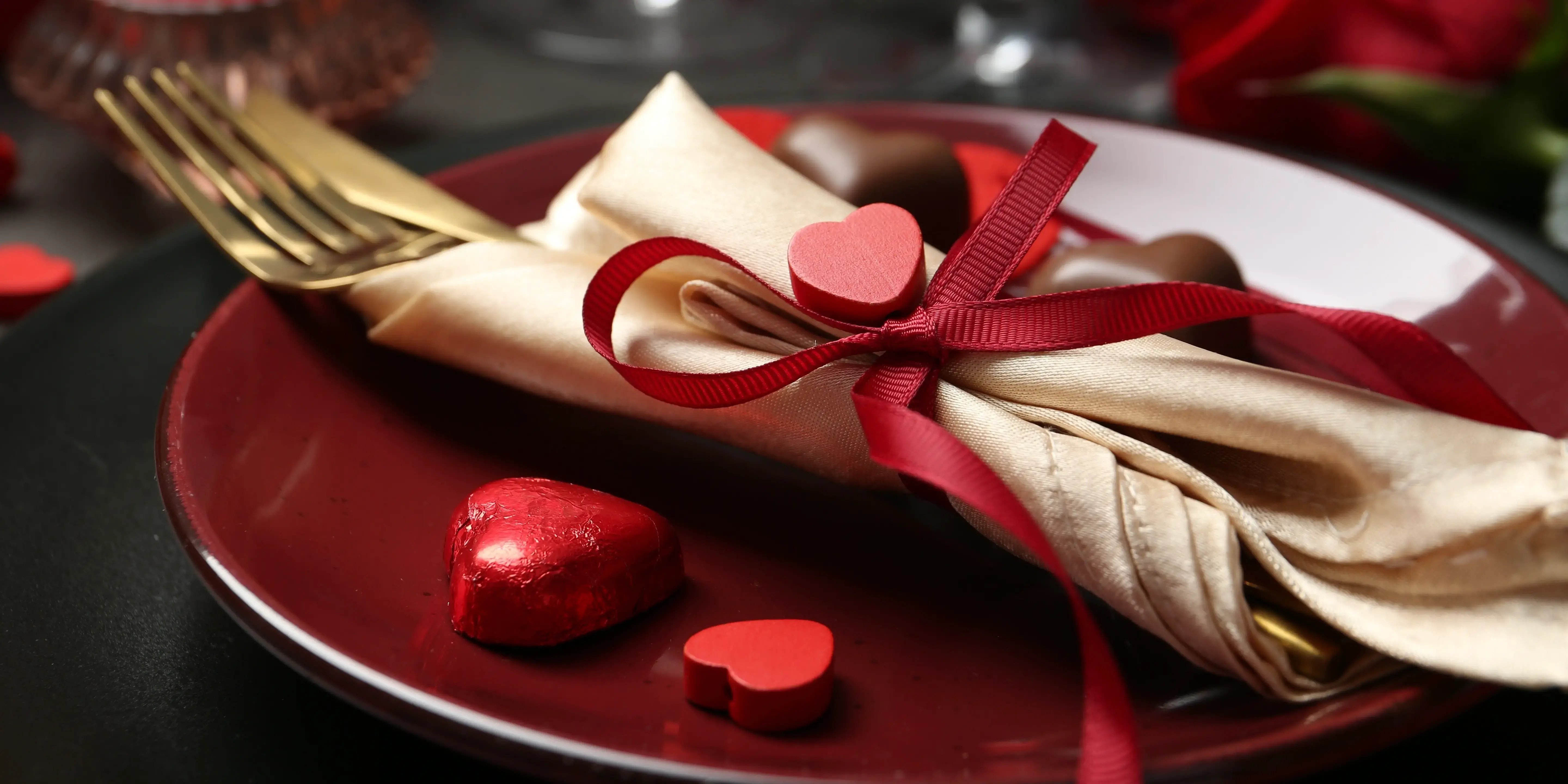 Mesa, corazones y plato rojo. San Valentín en casa