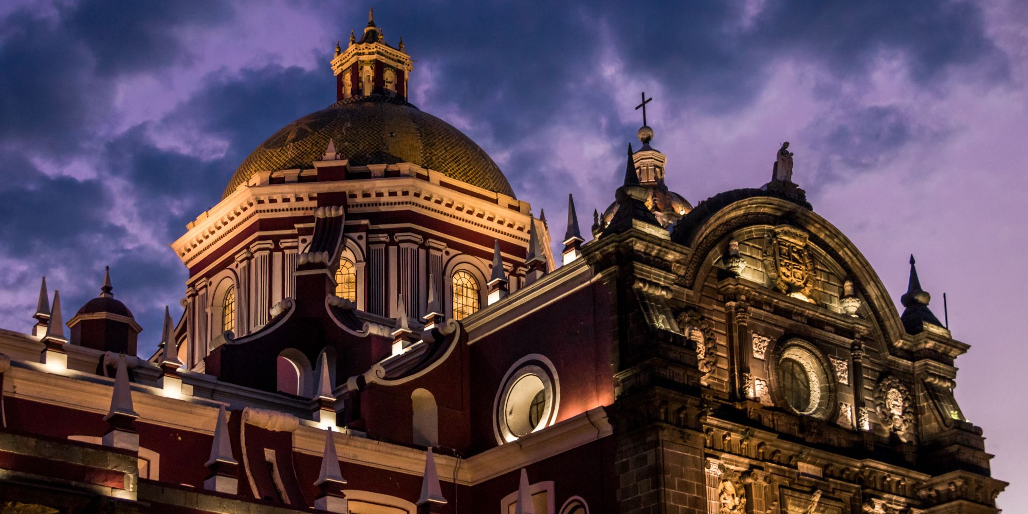Catedrál de Puebla de noche. Iluminada por luces que dejan ver su fachada.
