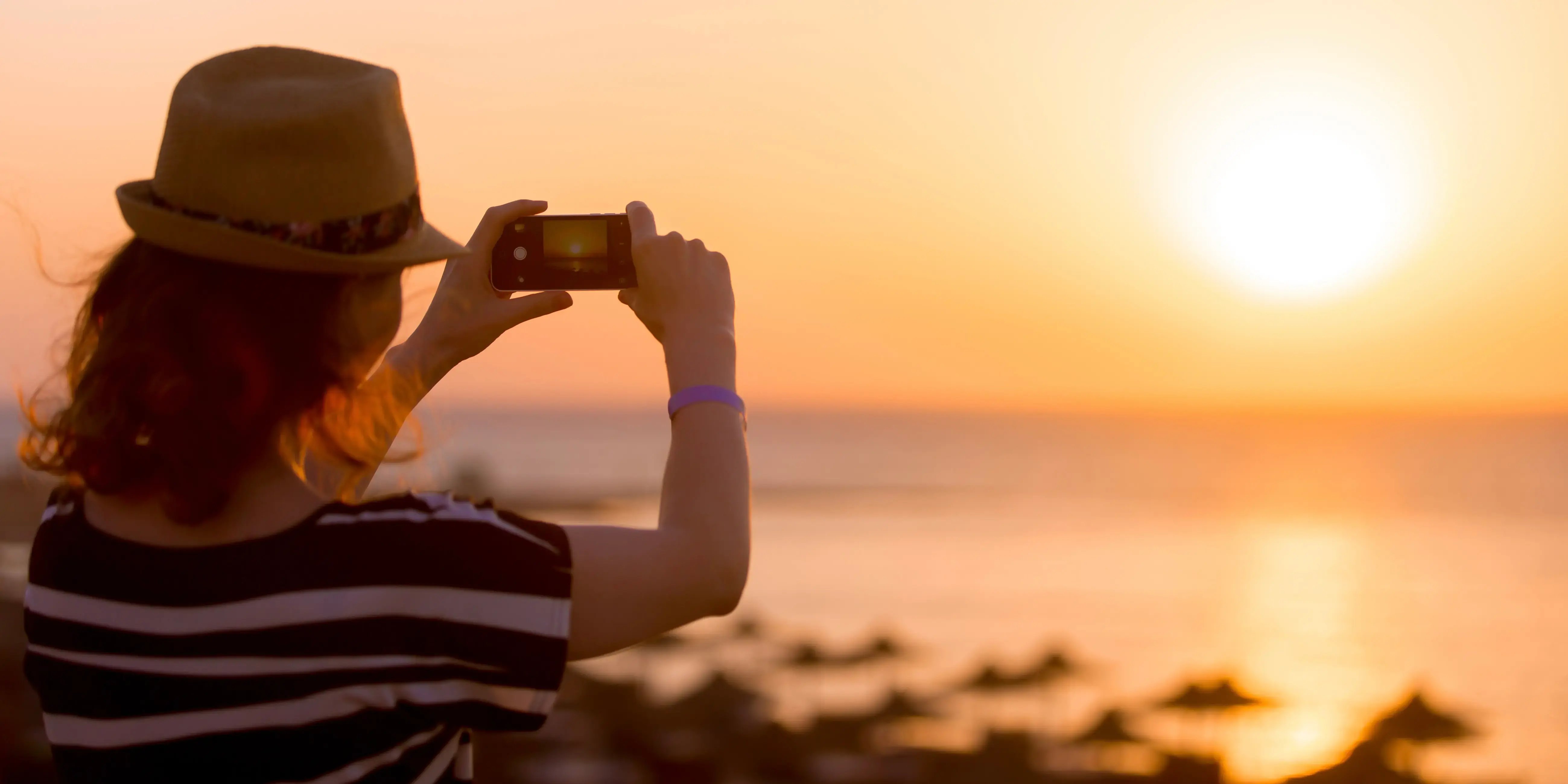 Mujer tomando foto del amanecer. Fotos de viajes